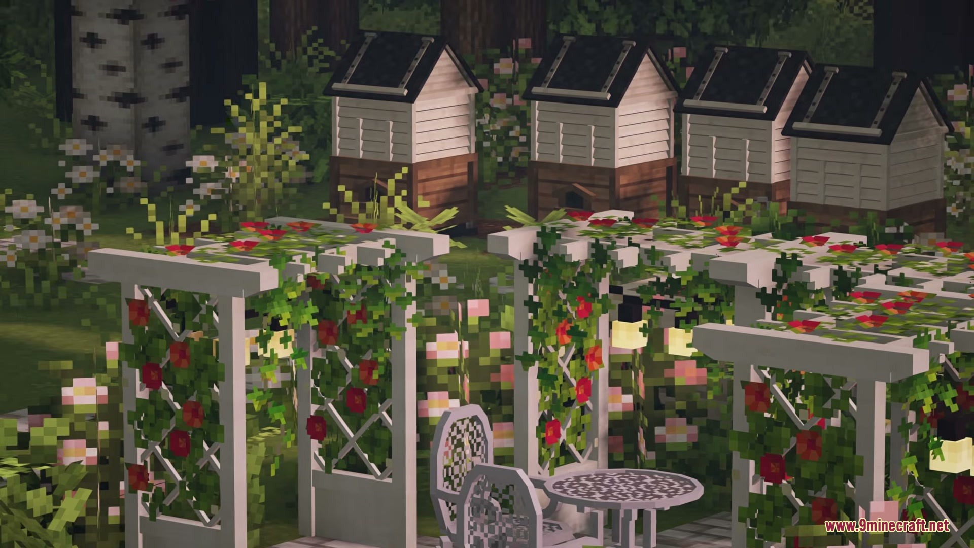 White garden trellises with red flowers and beehives in the background