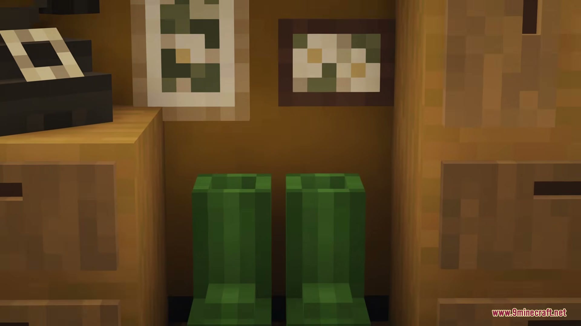 Green rubber boots sitting on the floor between two wooden cabinets