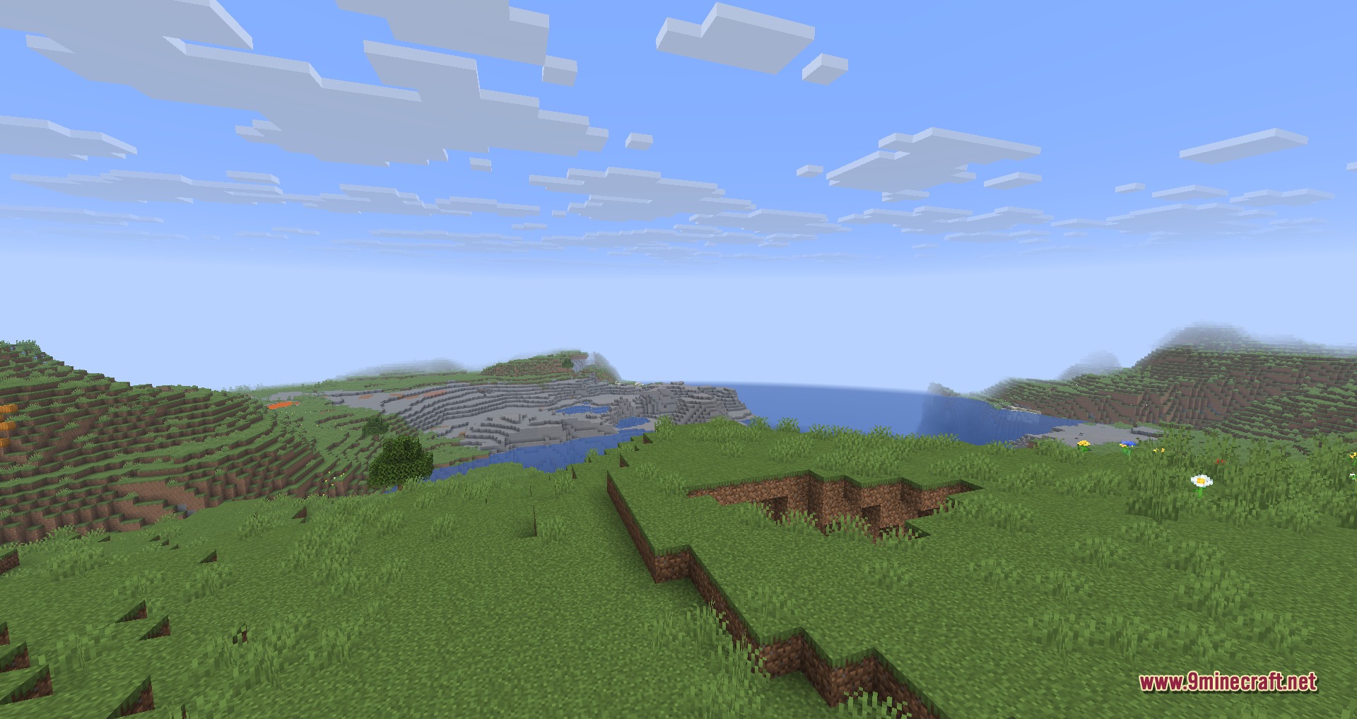 A scenic Minecraft landscape featuring rolling green hills and a blue ocean