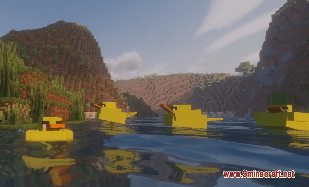 Yellow ducks swimming in a river with mountains in the background