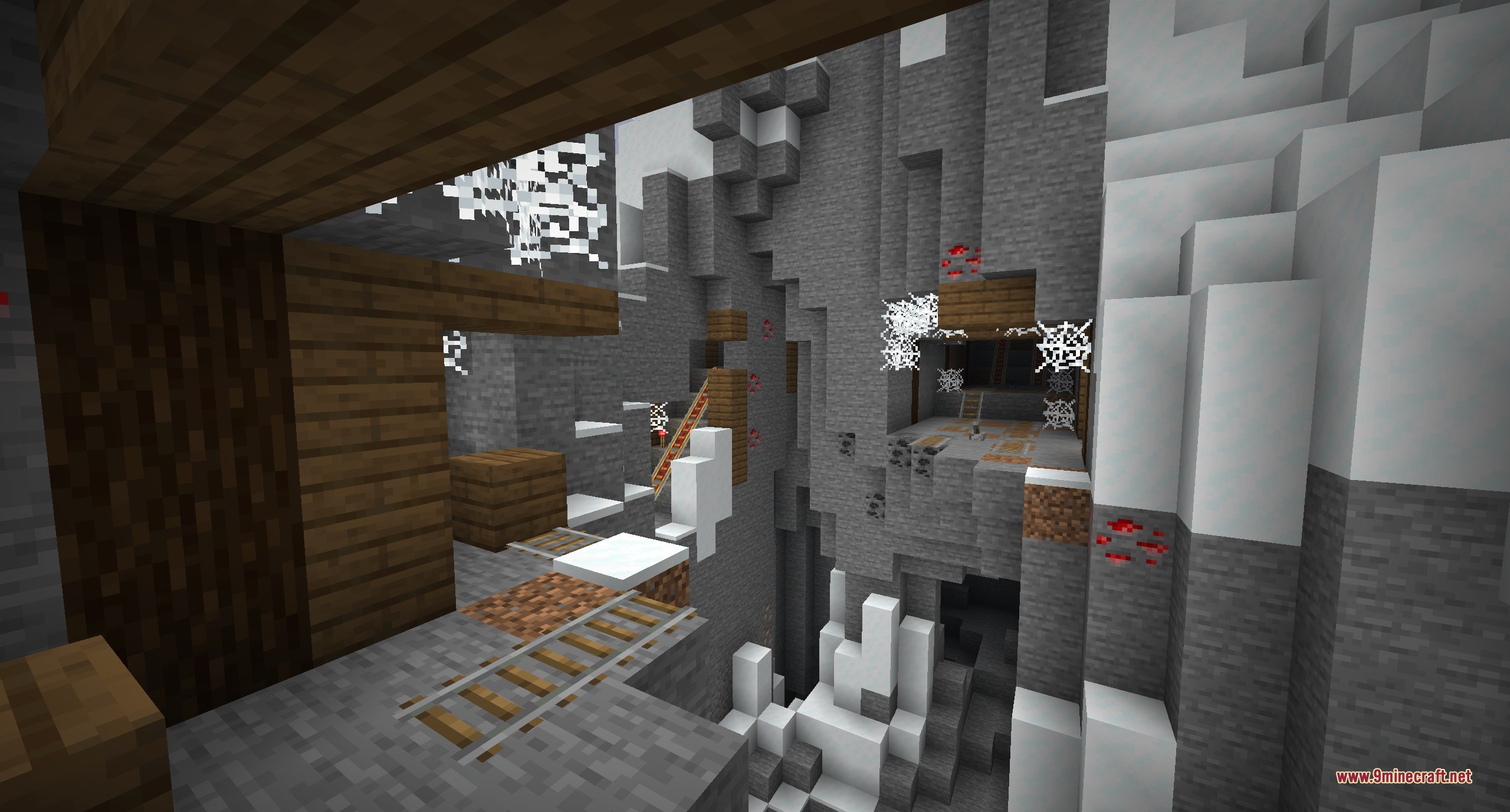 Dungeons and Taverns Mineshaft Overhaul Data Pack Screenshot 10 Snowy mountain mineshaft featuring redstone ore deposits and rails over a deep ravine