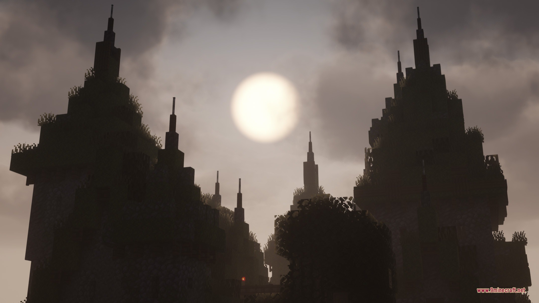 Tall stone towers silhouetted against a bright sun in a cloudy gray sky
