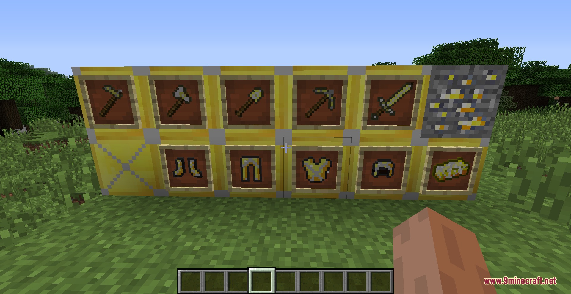 Reinforced gold armor and tool sets displayed on a wall of gold blocks