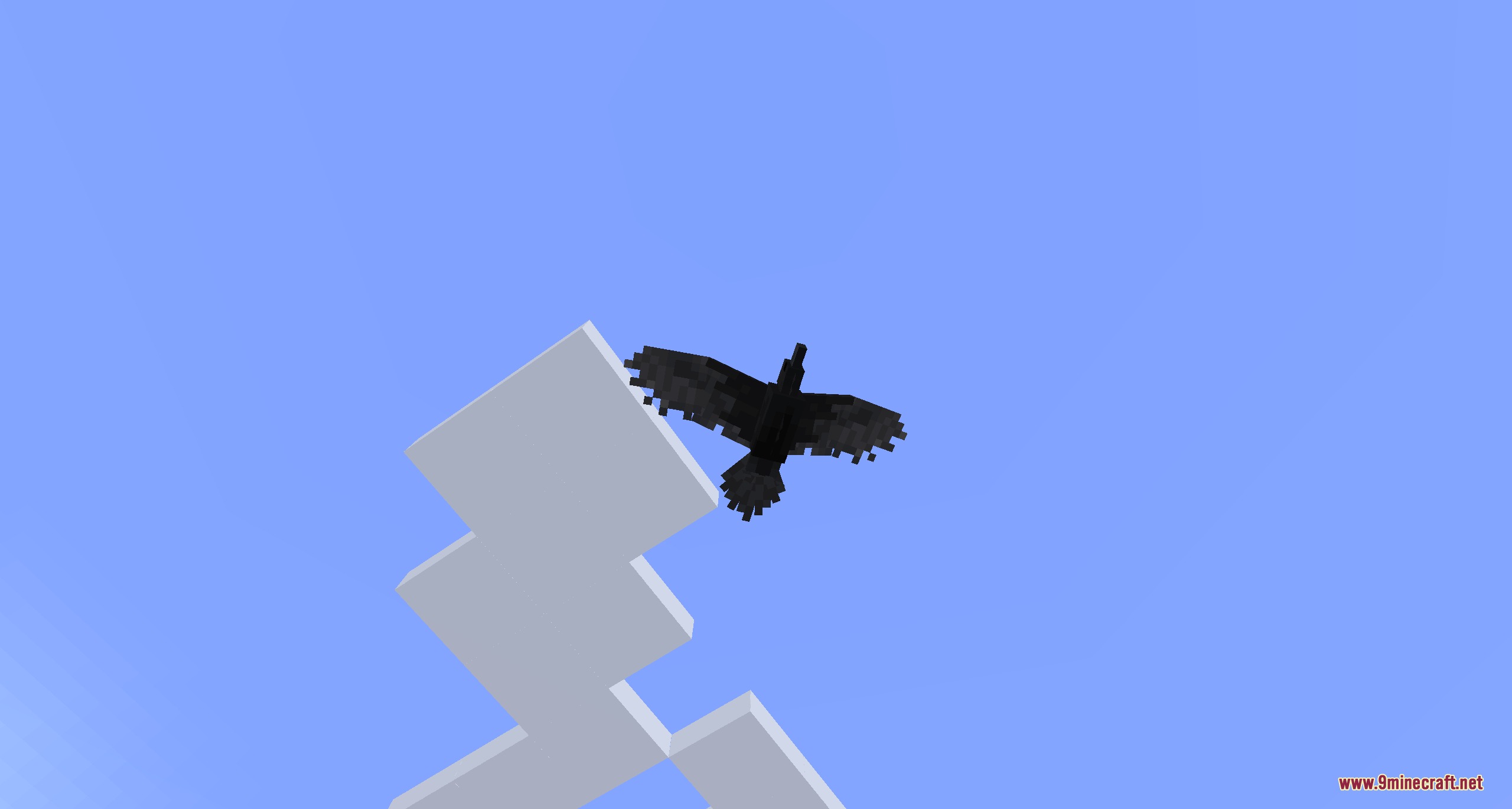A large black raven soaring through the clear blue sky near clouds
