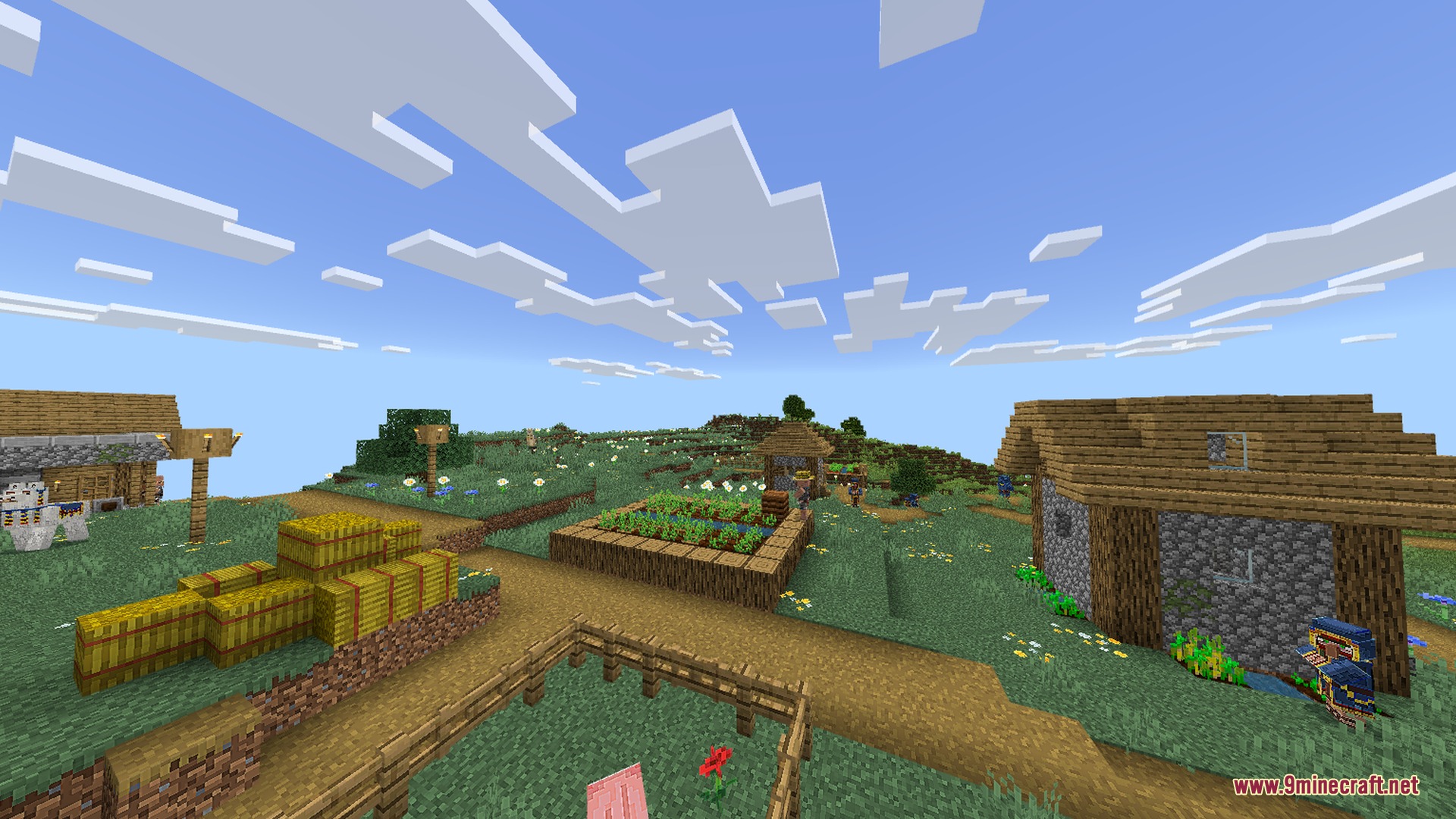 Vibrant Minecraft village featuring hay bales and a small farm plot