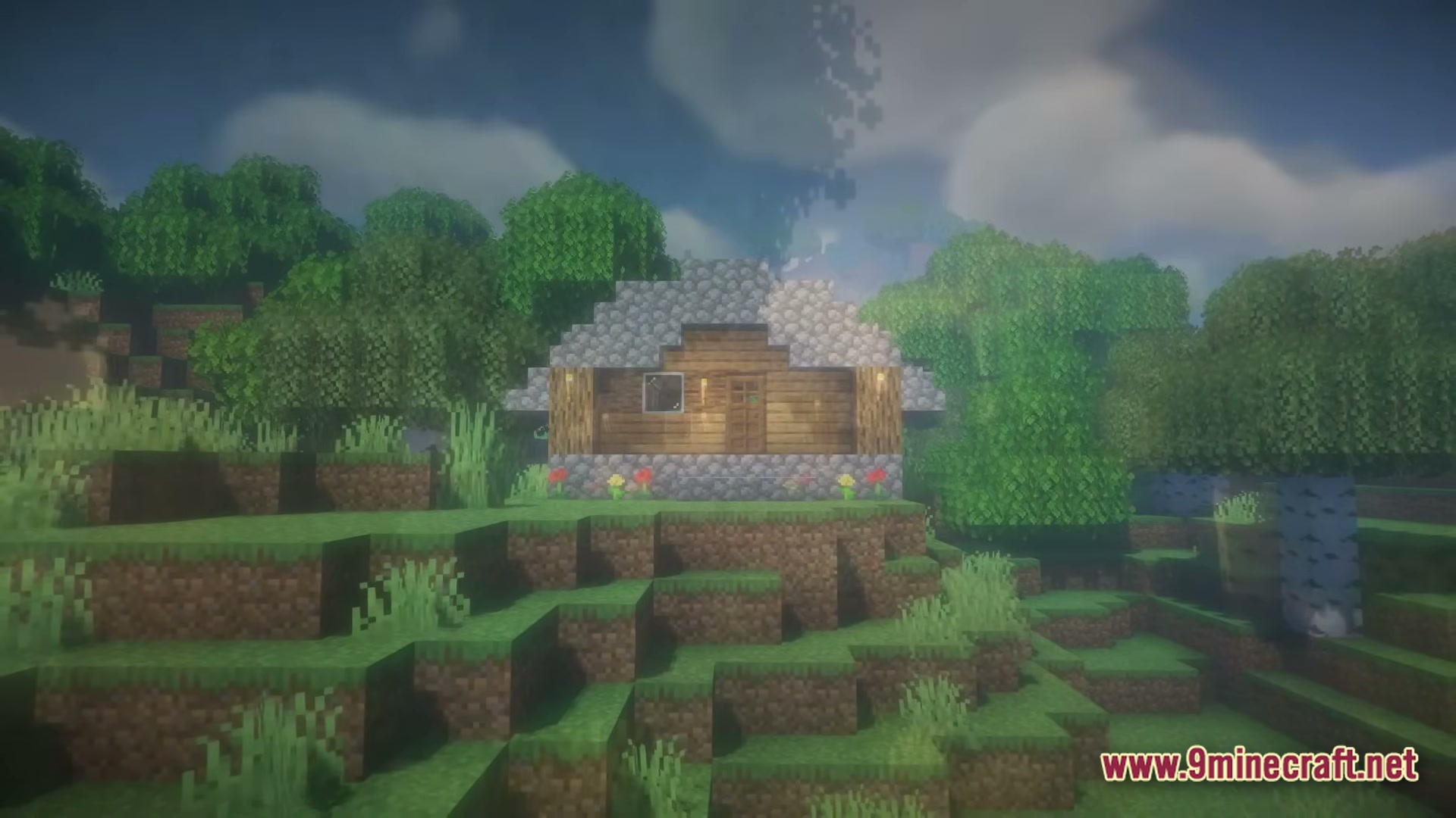From The Fog Modpack Screenshot 4 A small cobblestone and wood house sits on a grassy hill surrounded by dense green trees