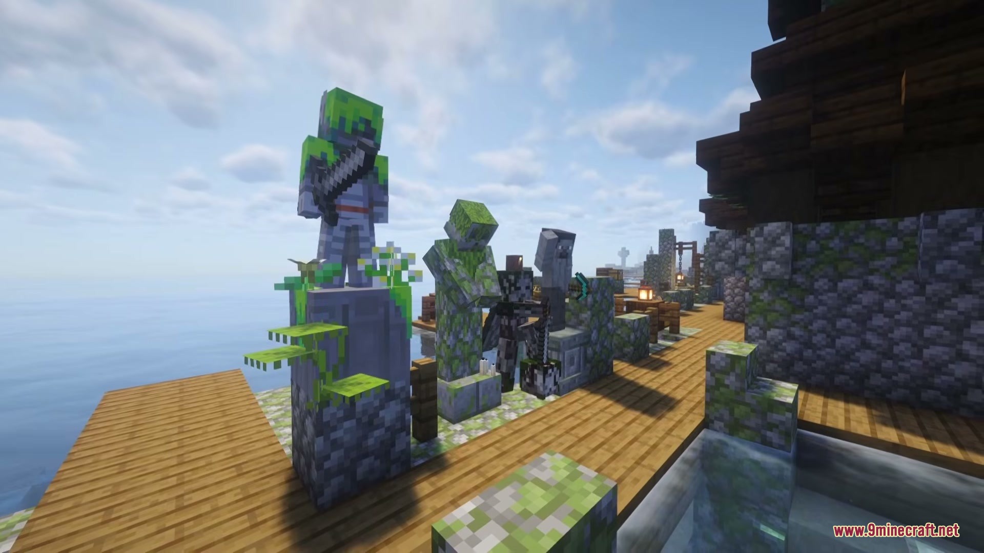 Several mossy stone statues placed along a wooden dock near the water
