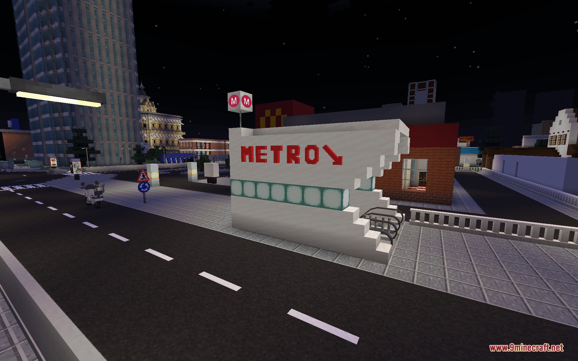 A city street at night featuring a red metro sign on a building