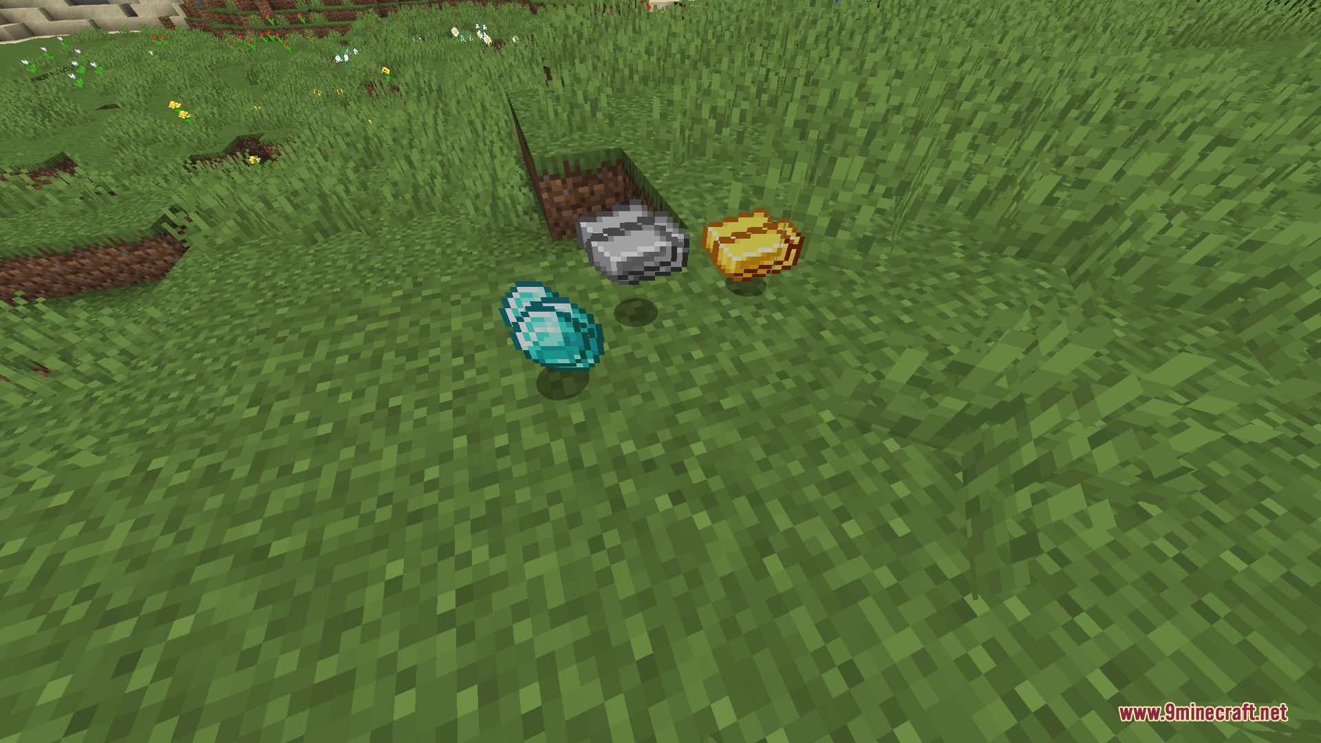 Diamond iron and gold ingots dropped on the grass as flat items