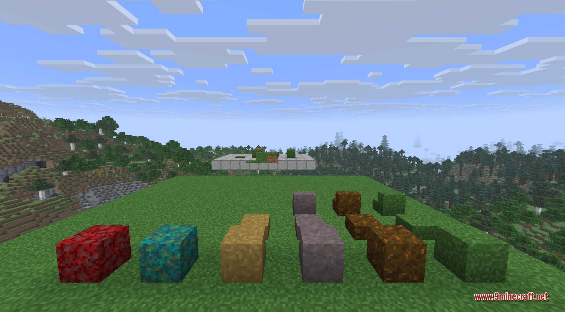 A row of colorful decorative grass blocks displayed on a flat grassy area