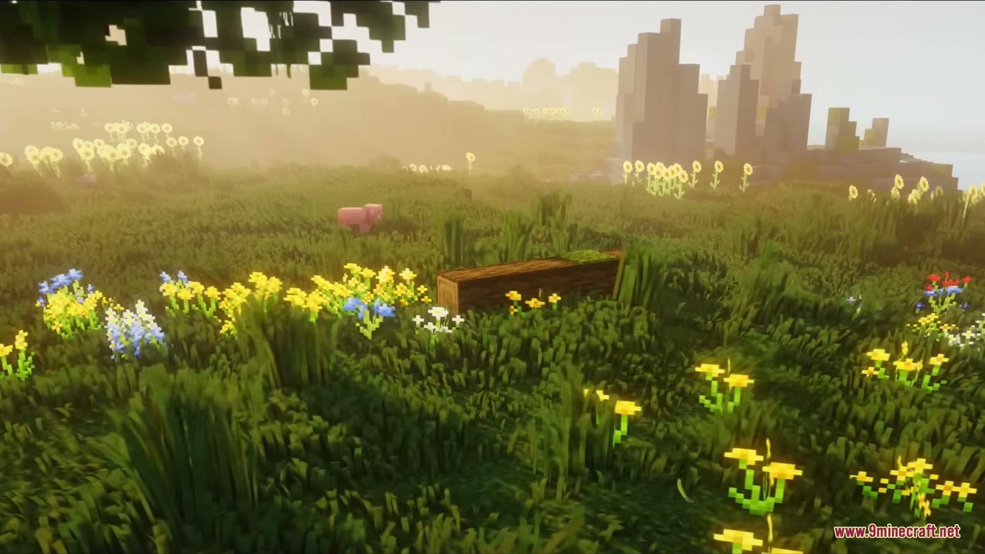 Grassier Grass Mod Screenshot 1 Vibrant Minecraft field with swaying grass and flowers under a hazy golden sky