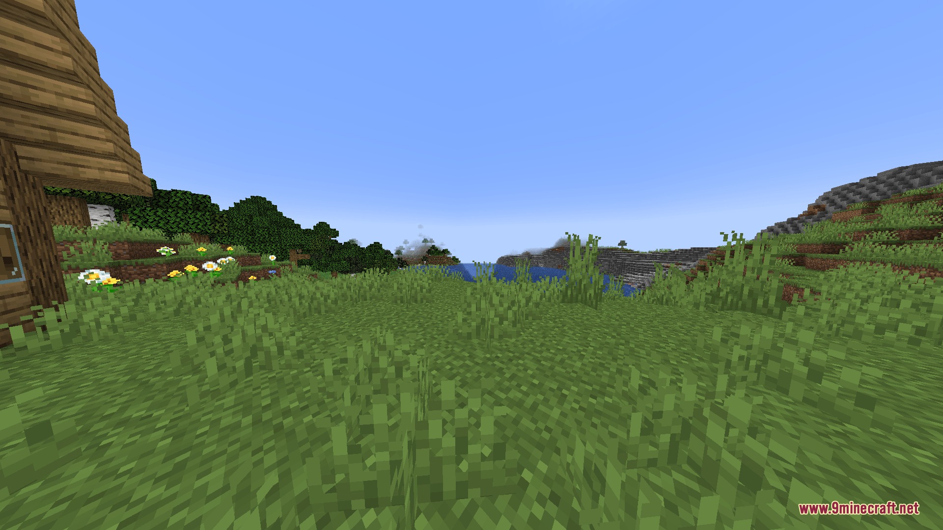 Hollow Altar Rite Mod Screenshot 5 A scenic Minecraft landscape with a wooden house and lush green fields