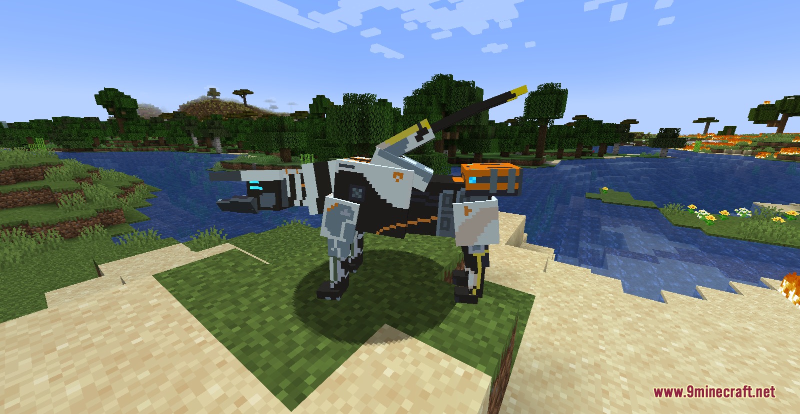 A mechanical Scrounger robot stands on a grassy hill near a river
