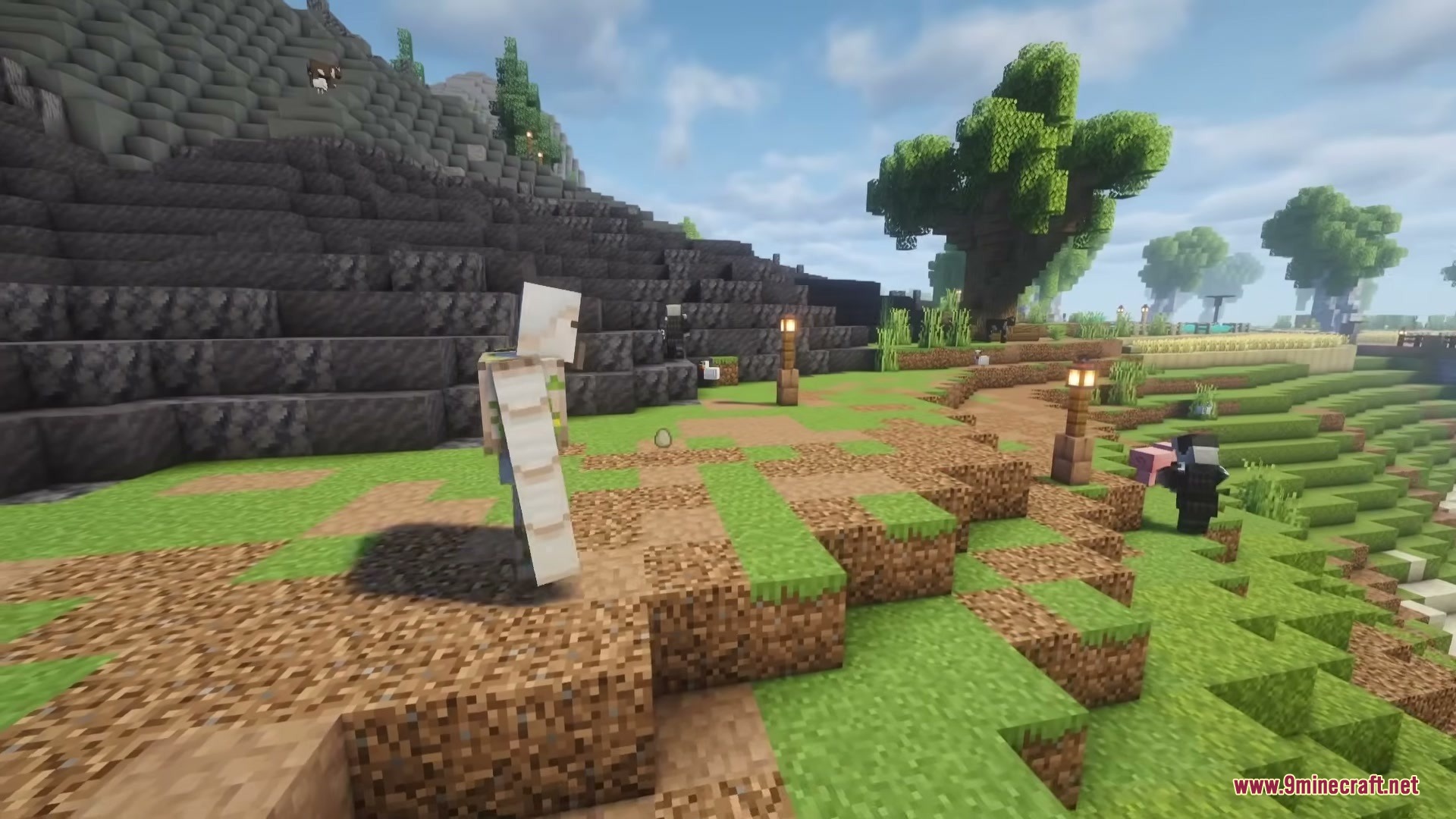 Illager Universe Mod Screenshot 3 An Iron Golem stands on a grassy path near a rocky mountain