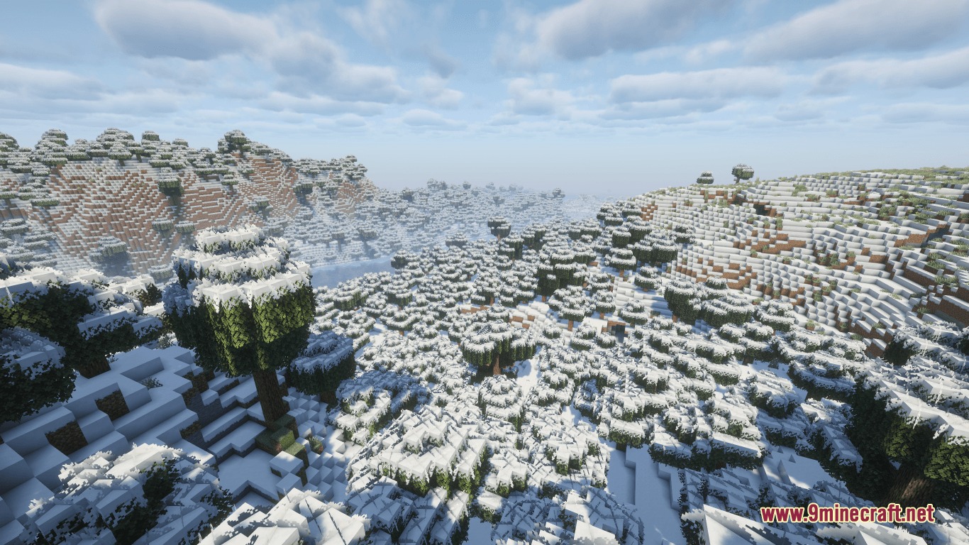 Bright snowy landscape with bushy trees and hills under a cloudy blue sky