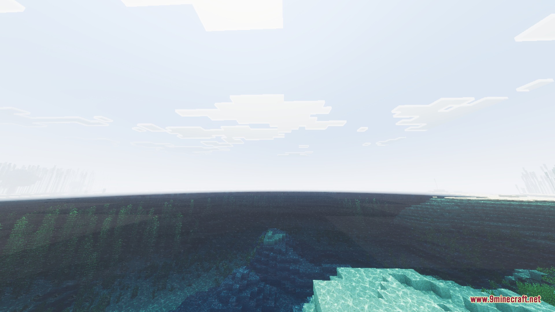 Clear ocean water reveals detailed underwater terrain under a bright and sunny sky