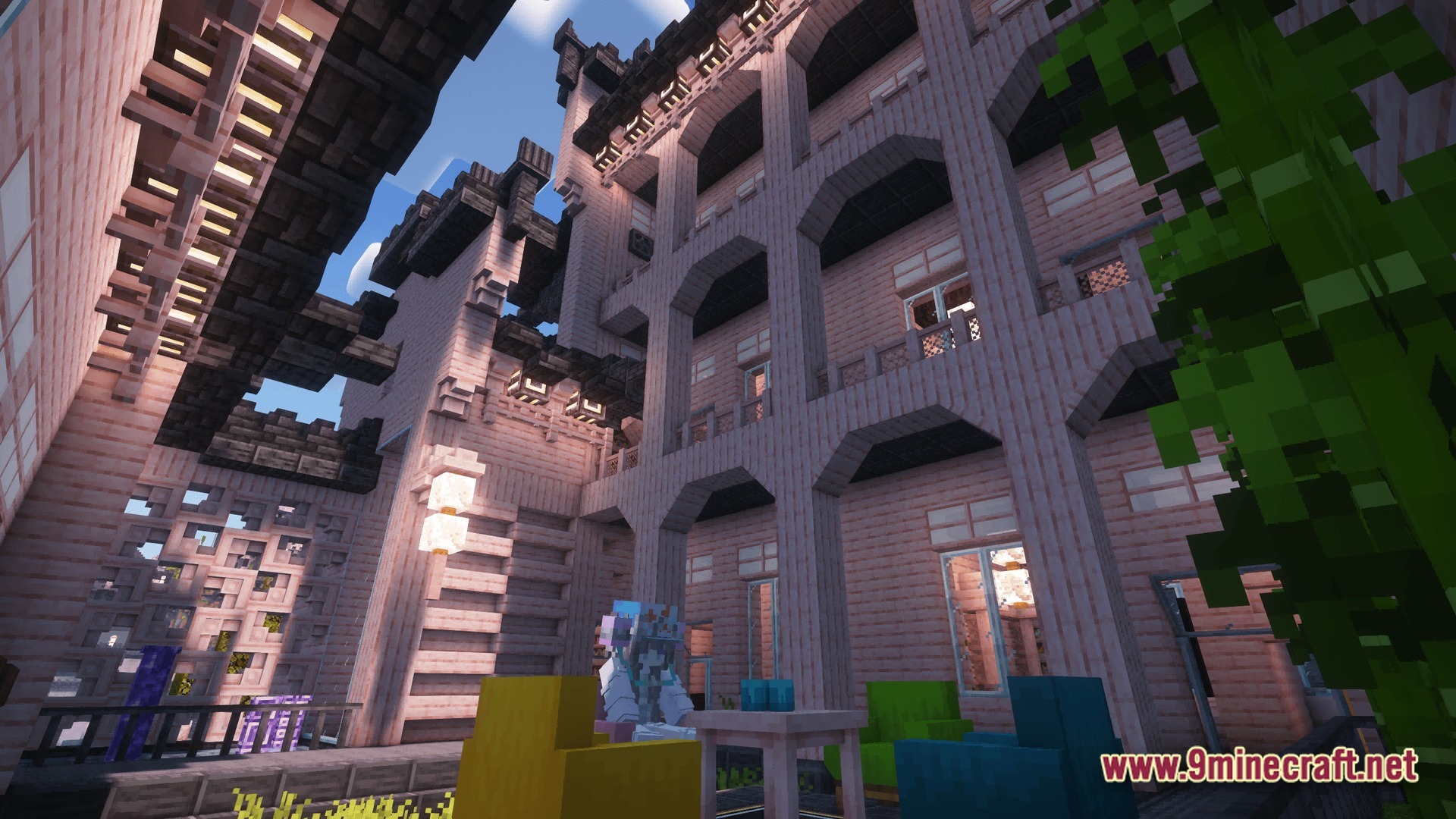Industrial Banquet Crucible Modpack Screenshot 9 A multi-story wooden building with arched balconies and colorful furniture in an outdoor courtyard area