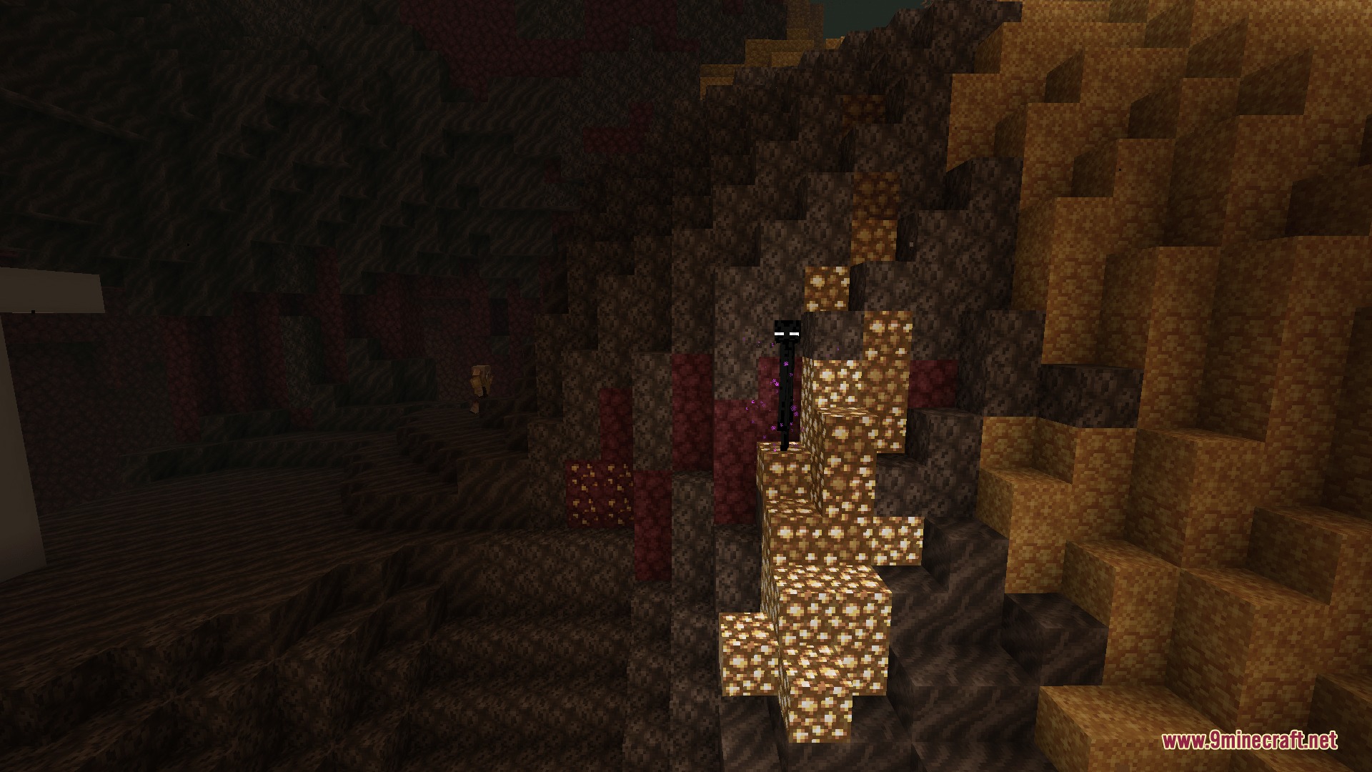 Infernal Expansion Redux Mod Screenshot 8 A tall Enderman stands on bright glowstone blocks against a dark cave wall