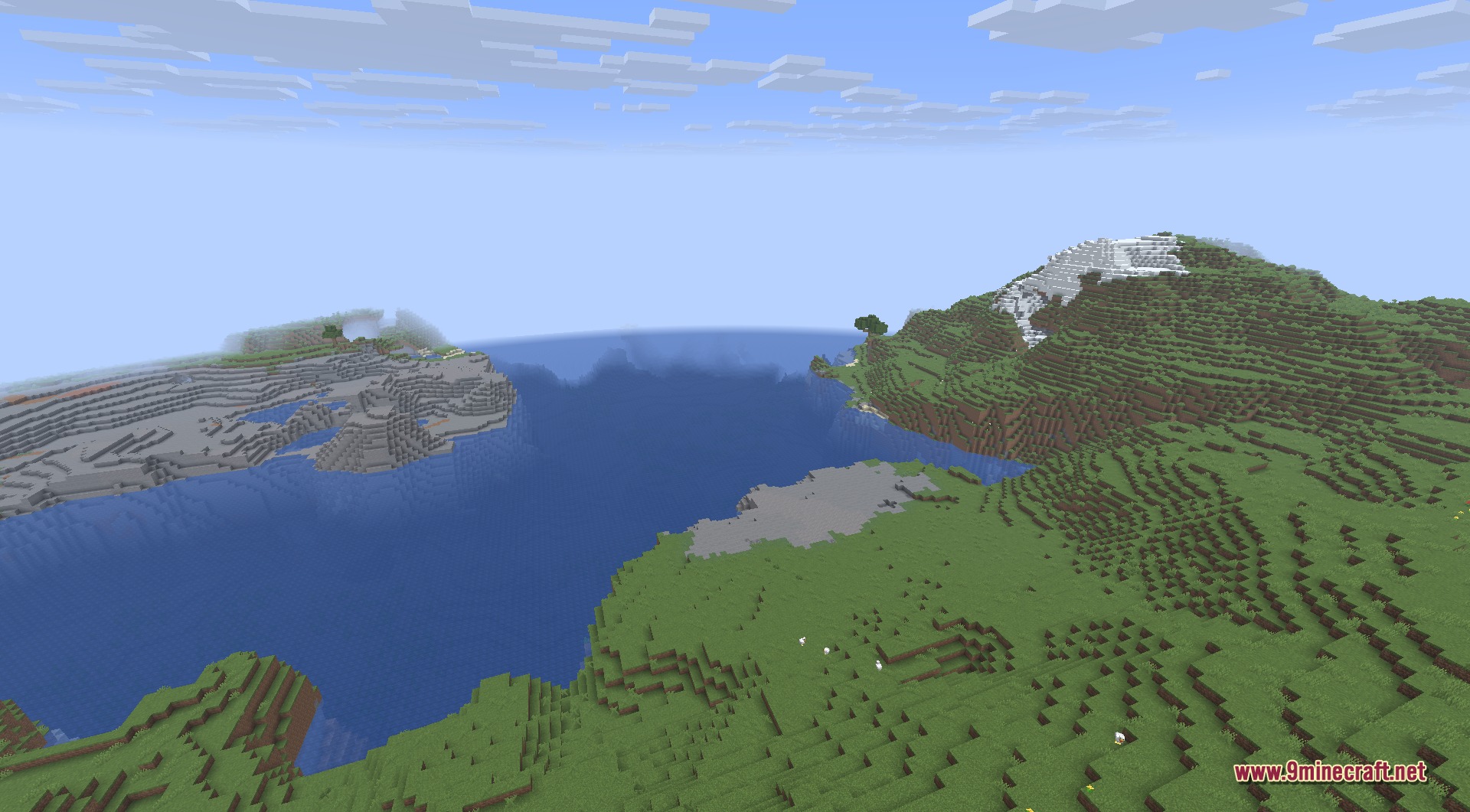 Infinite Music 9minecraft Mod Screenshot 5 A vast Minecraft ocean surrounded by green hills and a snowy mountain peak