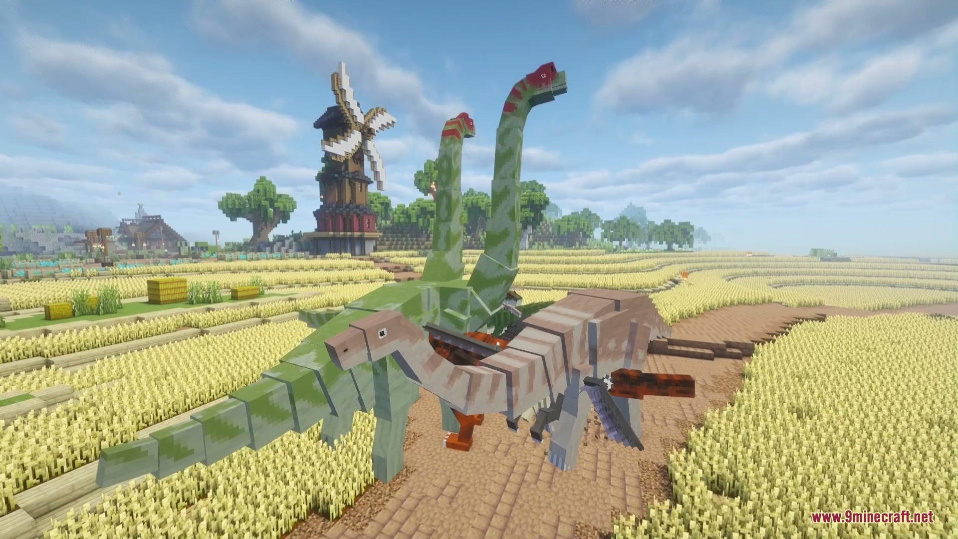 Jurassic Revived Mod Screenshot 1 Large long necked dinosaurs standing in a golden wheat field near a windmill