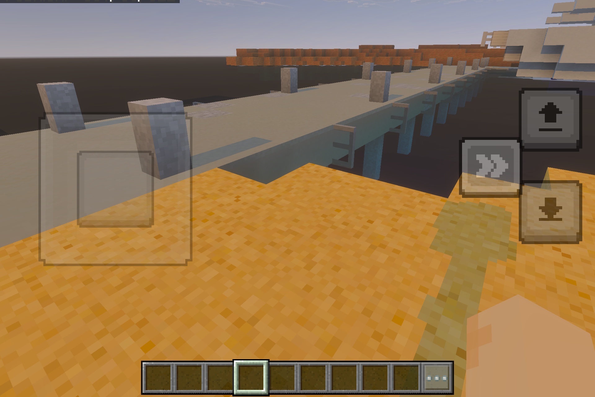 A long stone bridge and walkway structure built over water in Minecraft
