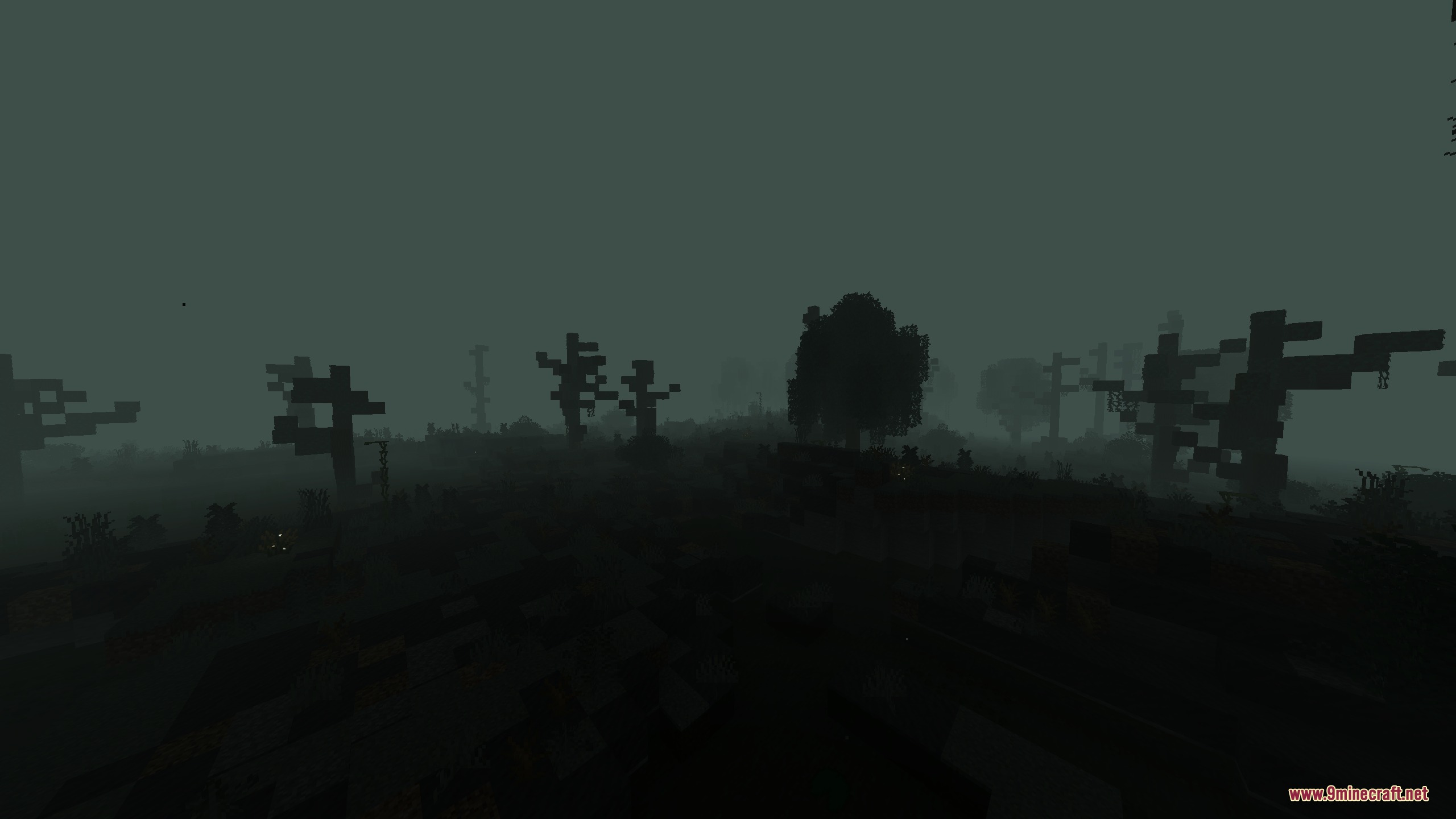 Eerie dead trees stand in a desolate biome covered in green fog