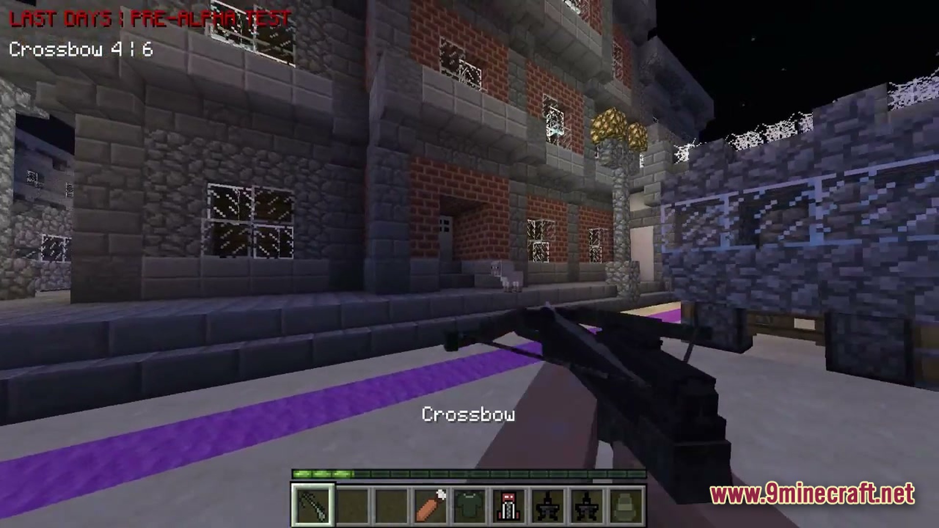 A player holds a crossbow in a first-person view while standing outside brick and stone buildings