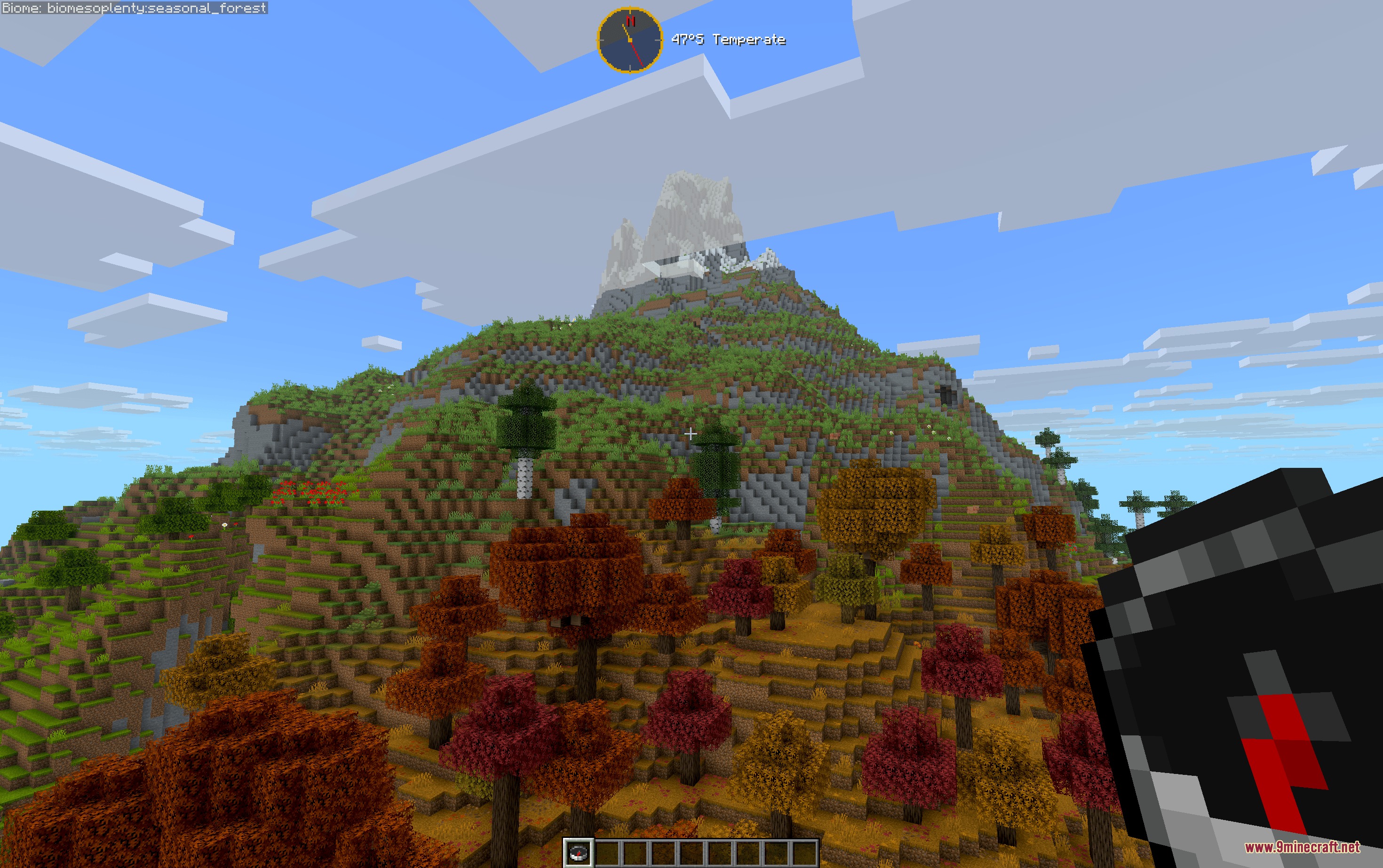 Latitude Mod Screenshot 1 Autumn forest on a hillside leading to a snowy mountain peak in Minecraft