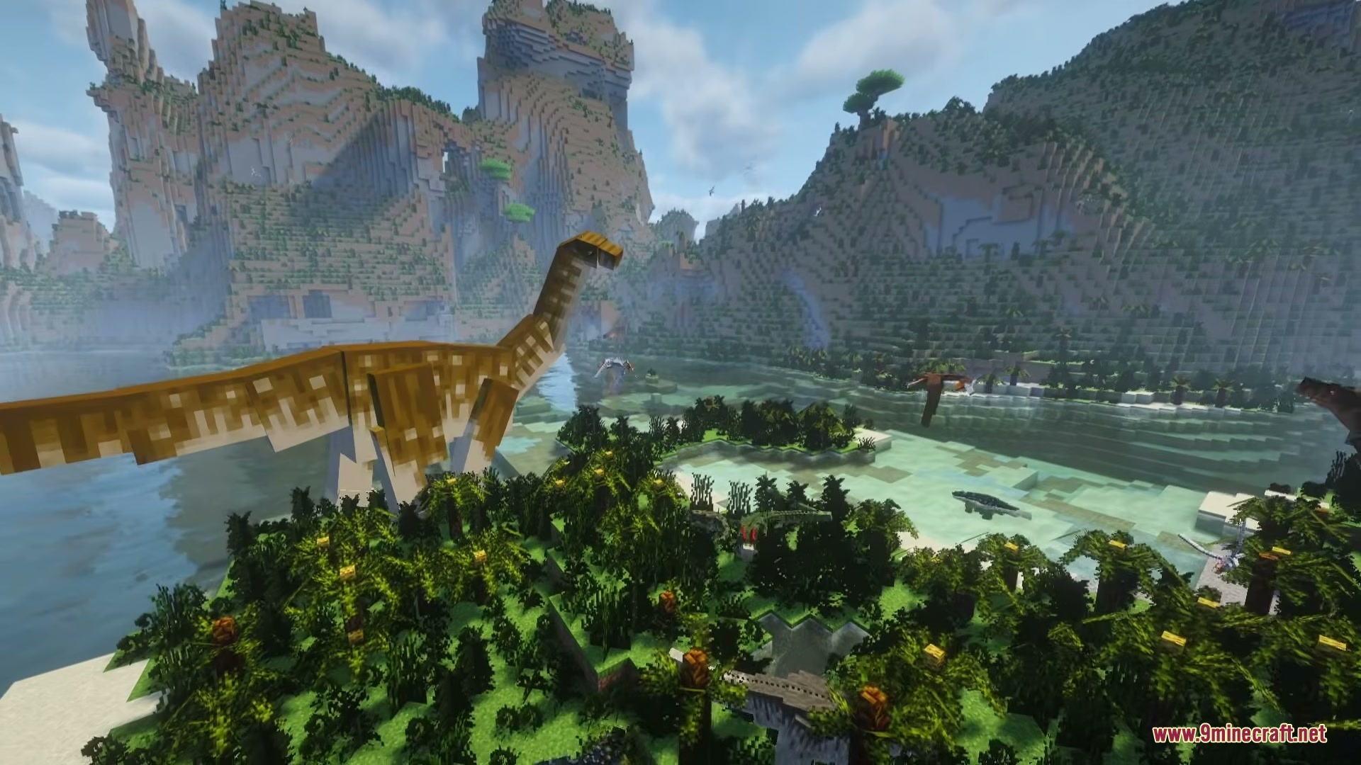 A giant long necked dinosaur stands among lush prehistoric vegetation and mountains