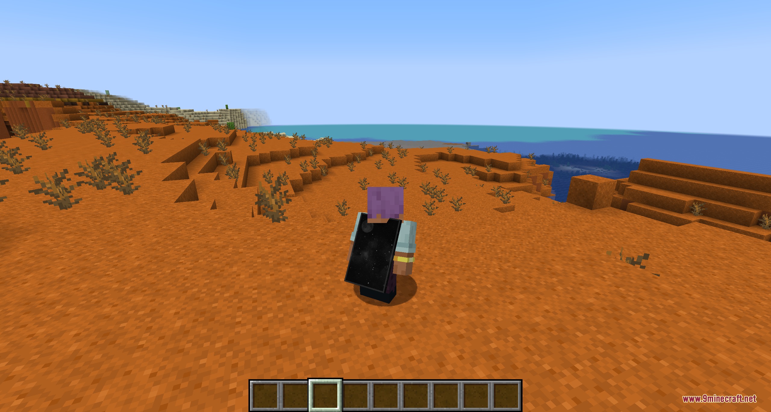 A player character wearing a starry black cape in a red sand biome