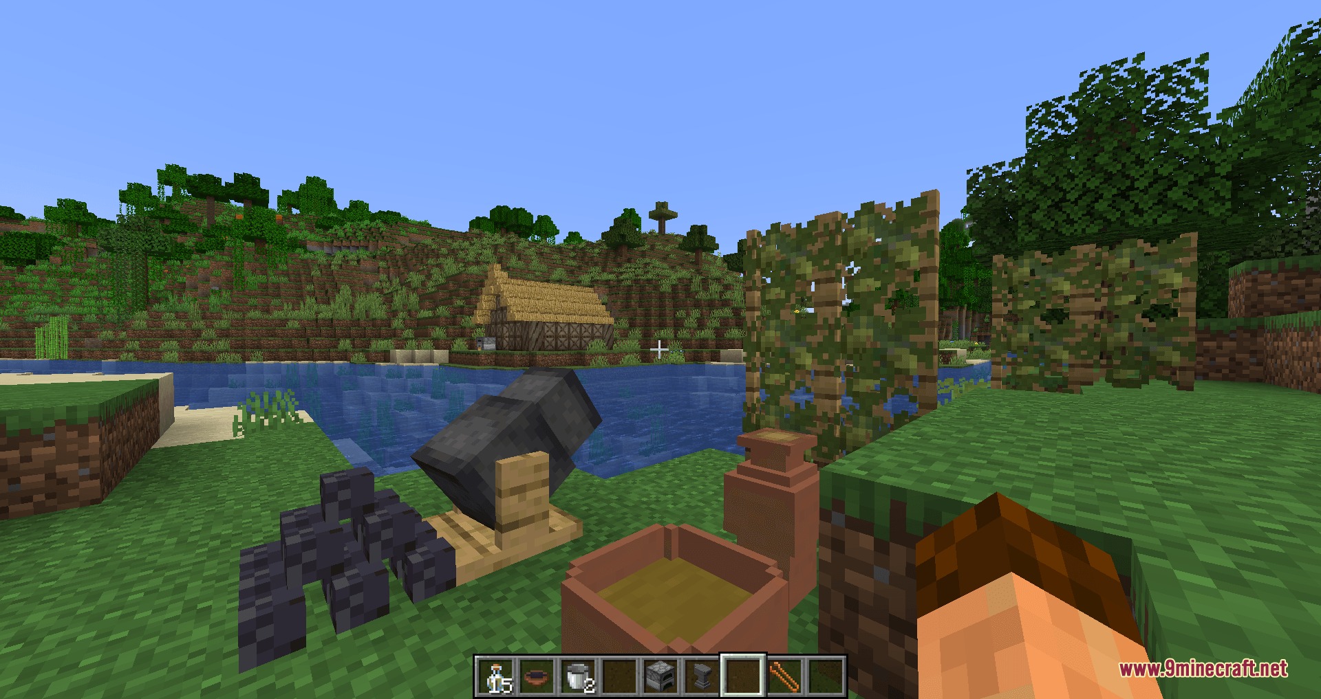 A primitive kiln and clay pots placed near a river bank