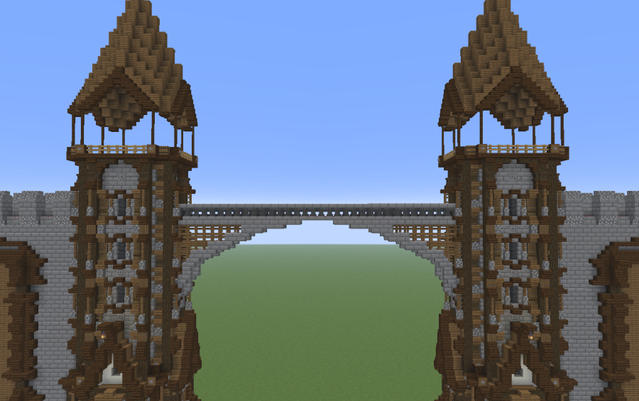 Two stone and wood towers connected by a stone arch bridge in Minecraft