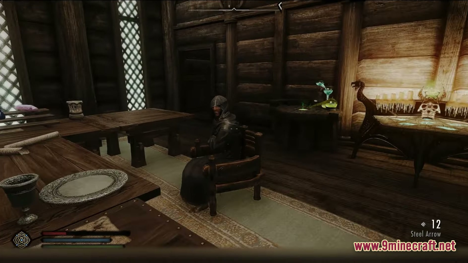 Modded Together Modpack Screenshot 4 A hooded character sits in a wooden interior featuring an alchemy station and enchanting table