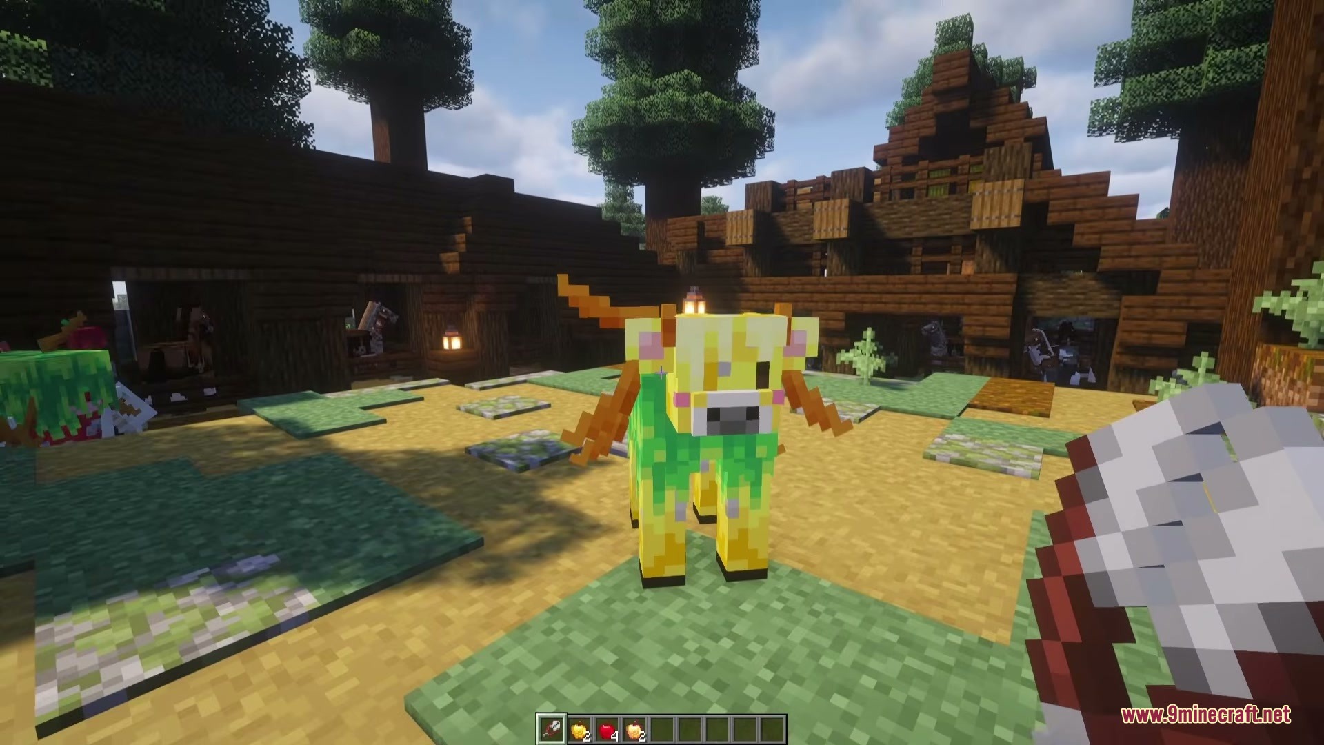 A golden apple cow standing in a village with wooden buildings and trees