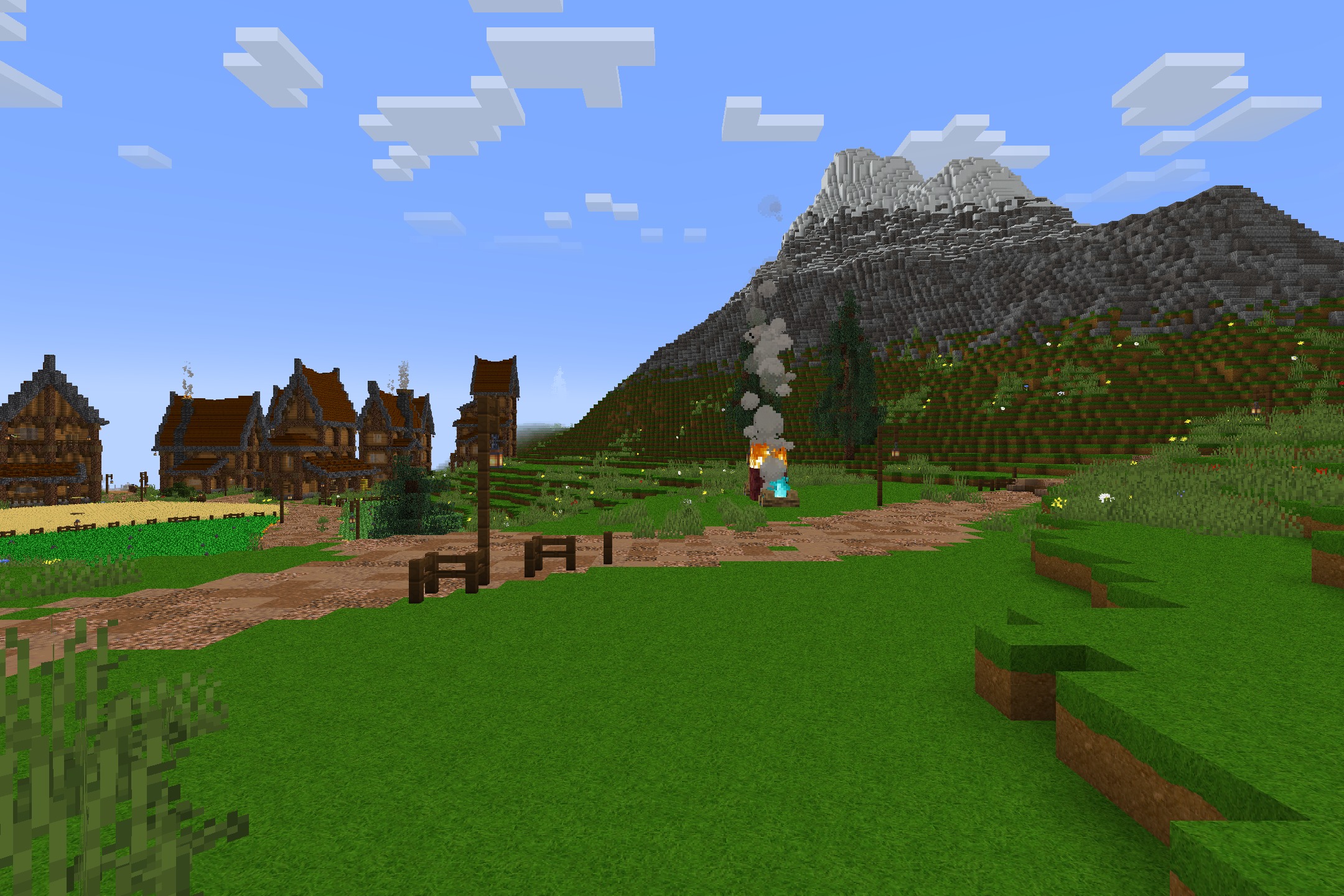 A peaceful village with stylized wooden houses and a large mountain background