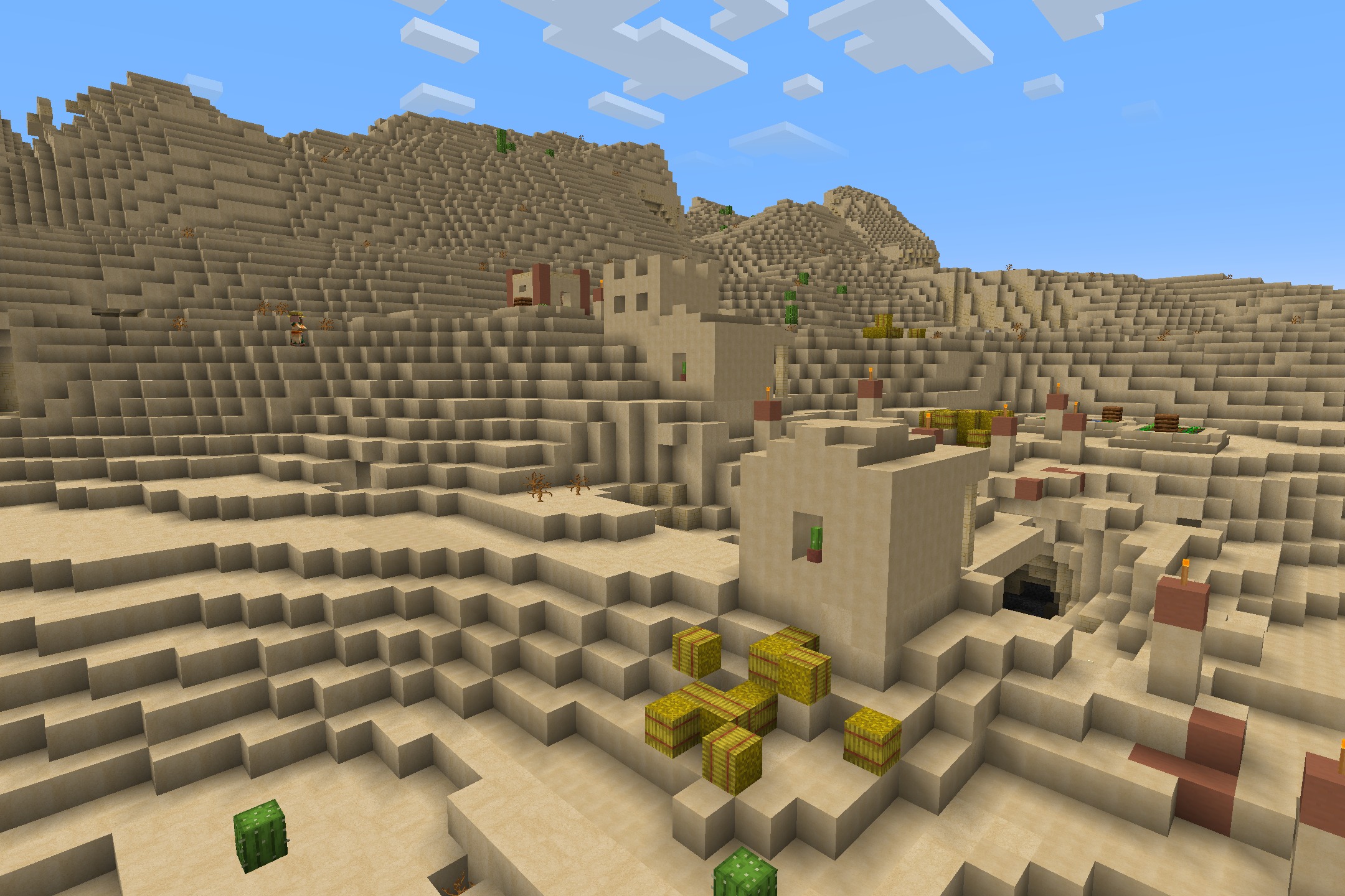 Stylized sandstone houses and hay bales in a desert biome with cartoon textures