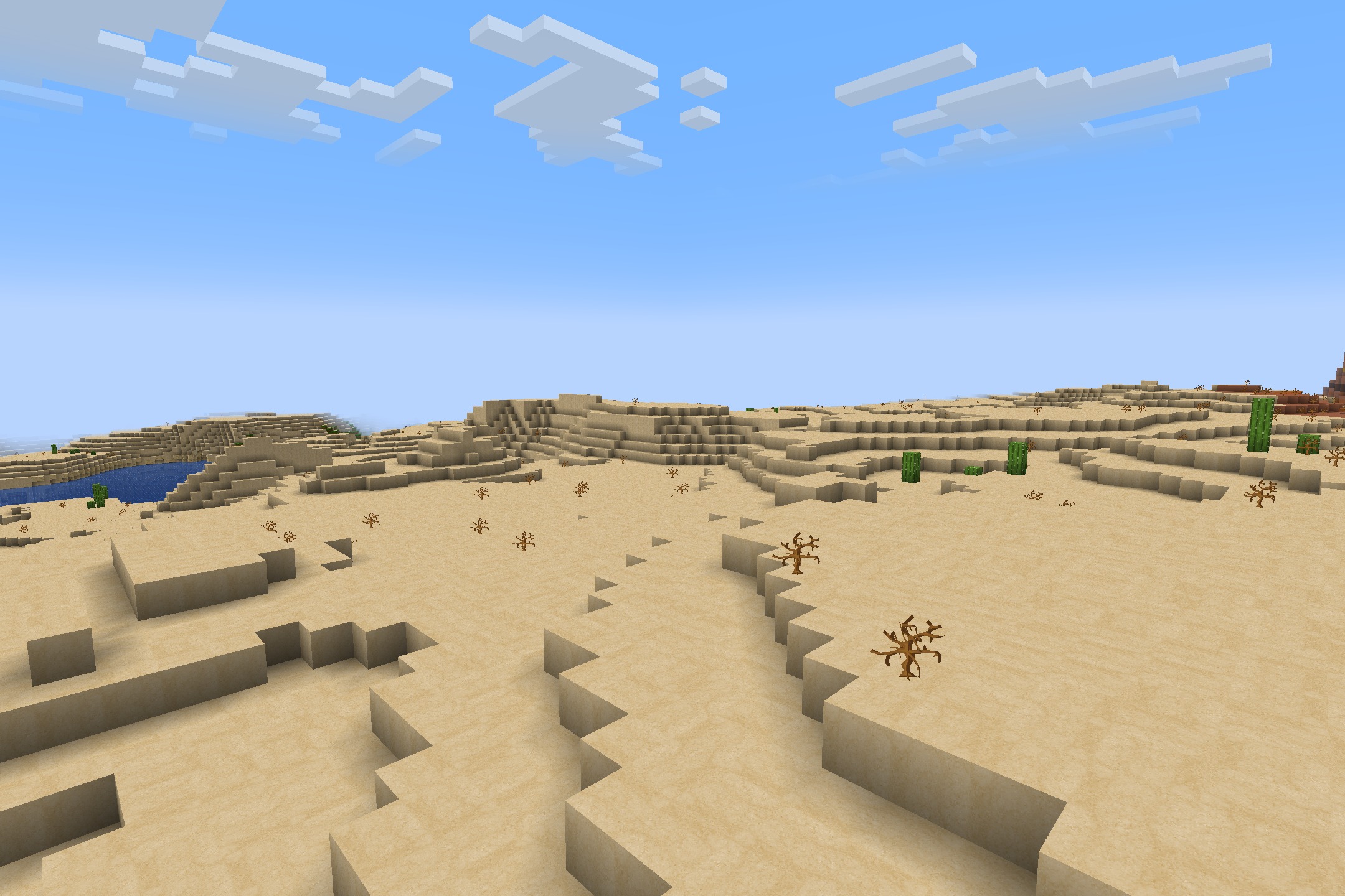 A bright desert biome with sand blocks cacti and dead bushes under clouds