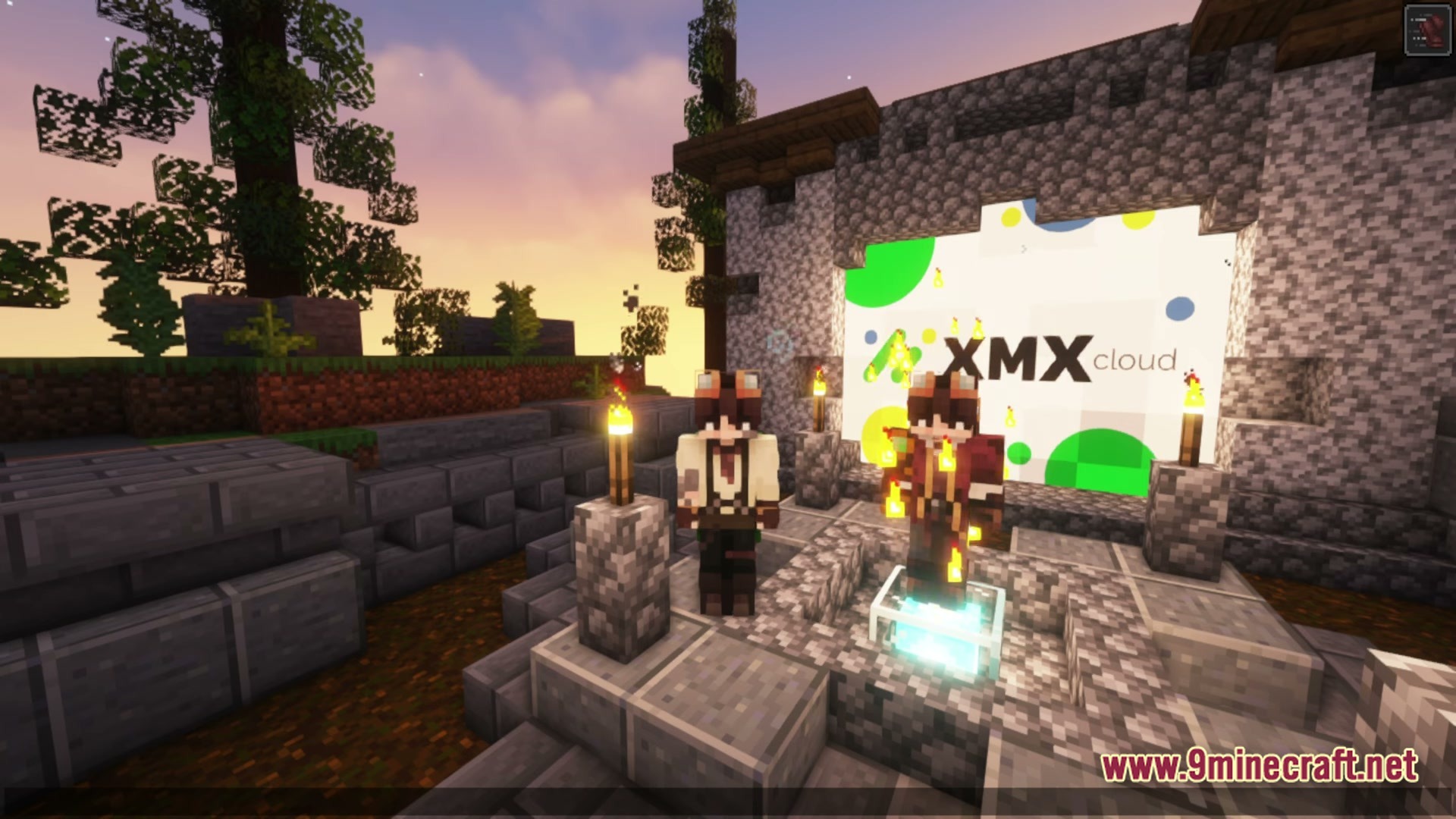 Two players stand before a stone structure featuring a large XMX cloud logo at sunset