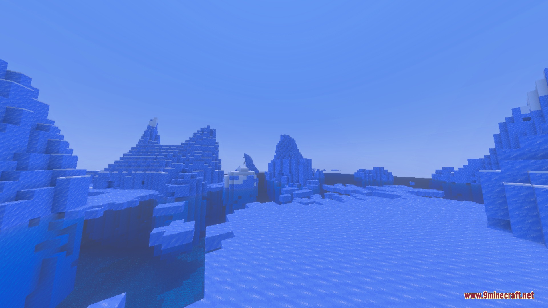 Vast icy landscape with blue ice formations under a clear blue sky