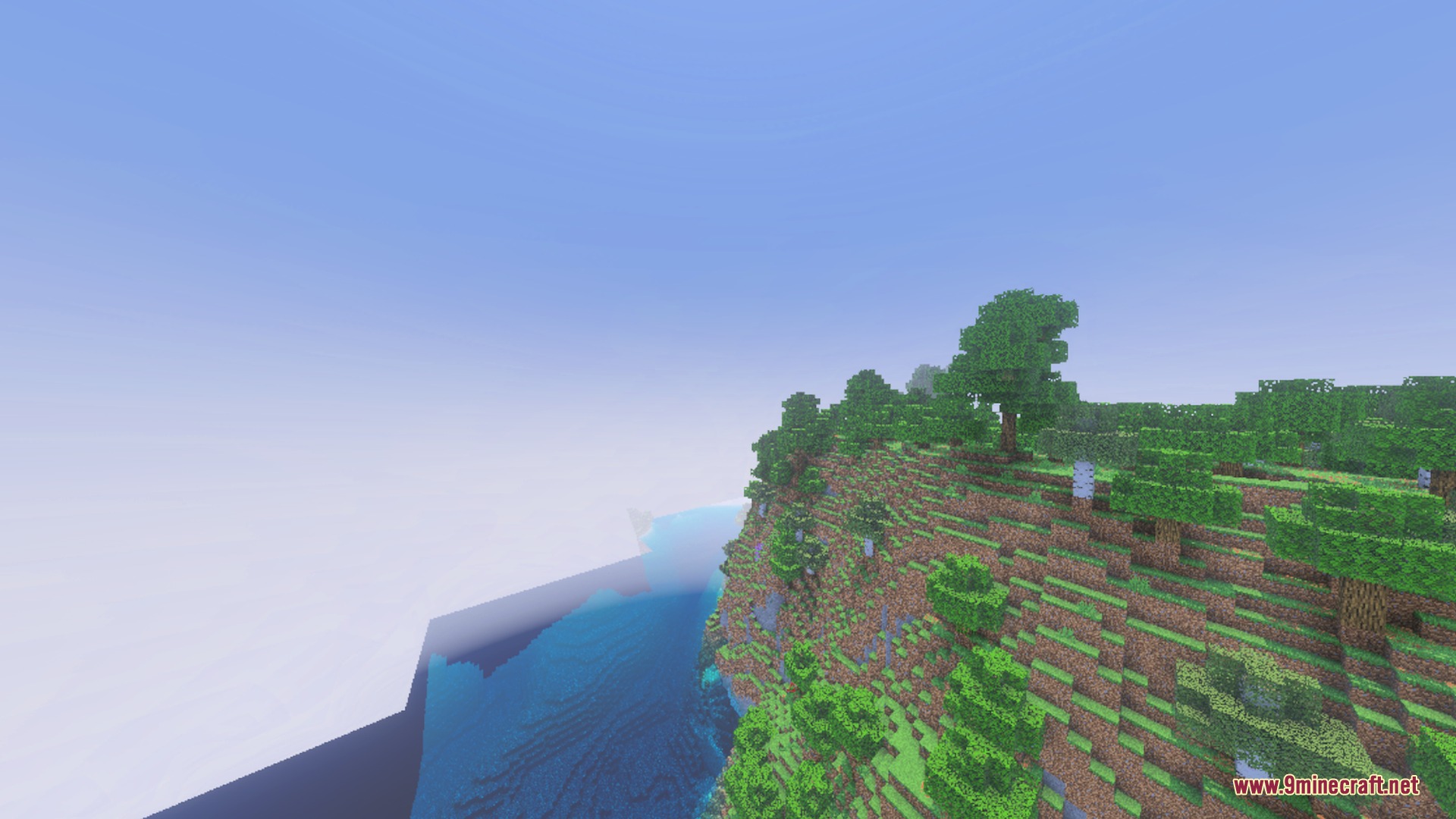 Vibrant green terrain and trees along a cliffside overlooking the clear blue water