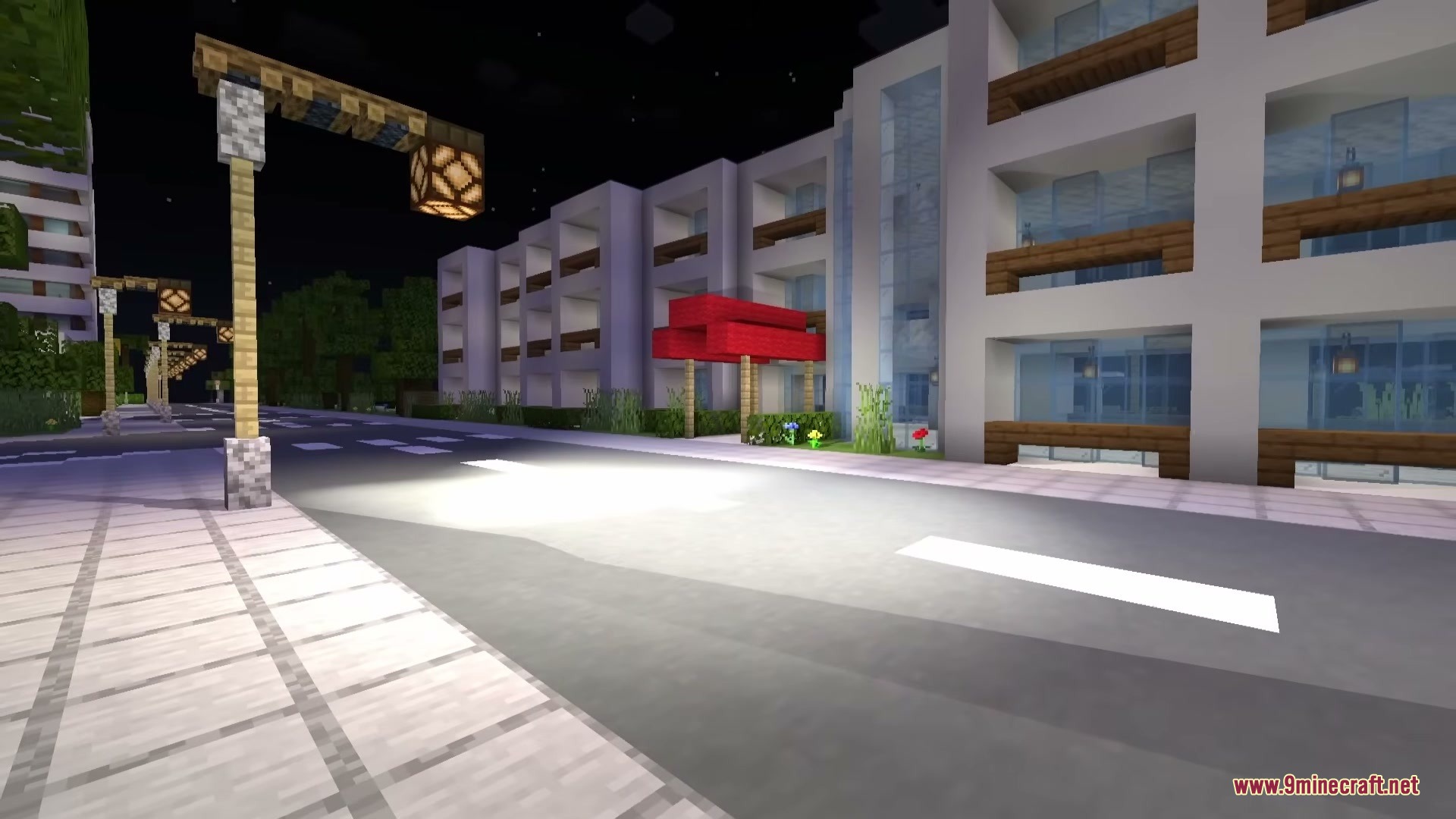 Omega Flashlight Mod Screenshot 4 A wide flashlight beam lights up a city street and modern apartment complex