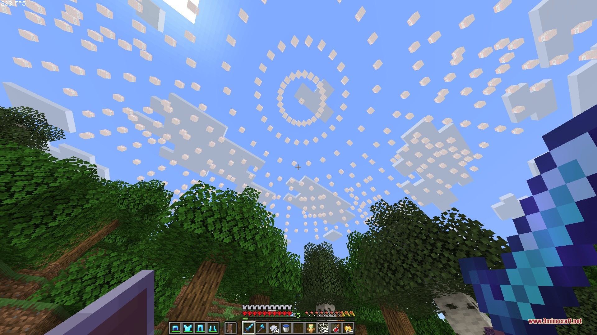 A white circular particle effect appears in the sky above the forest