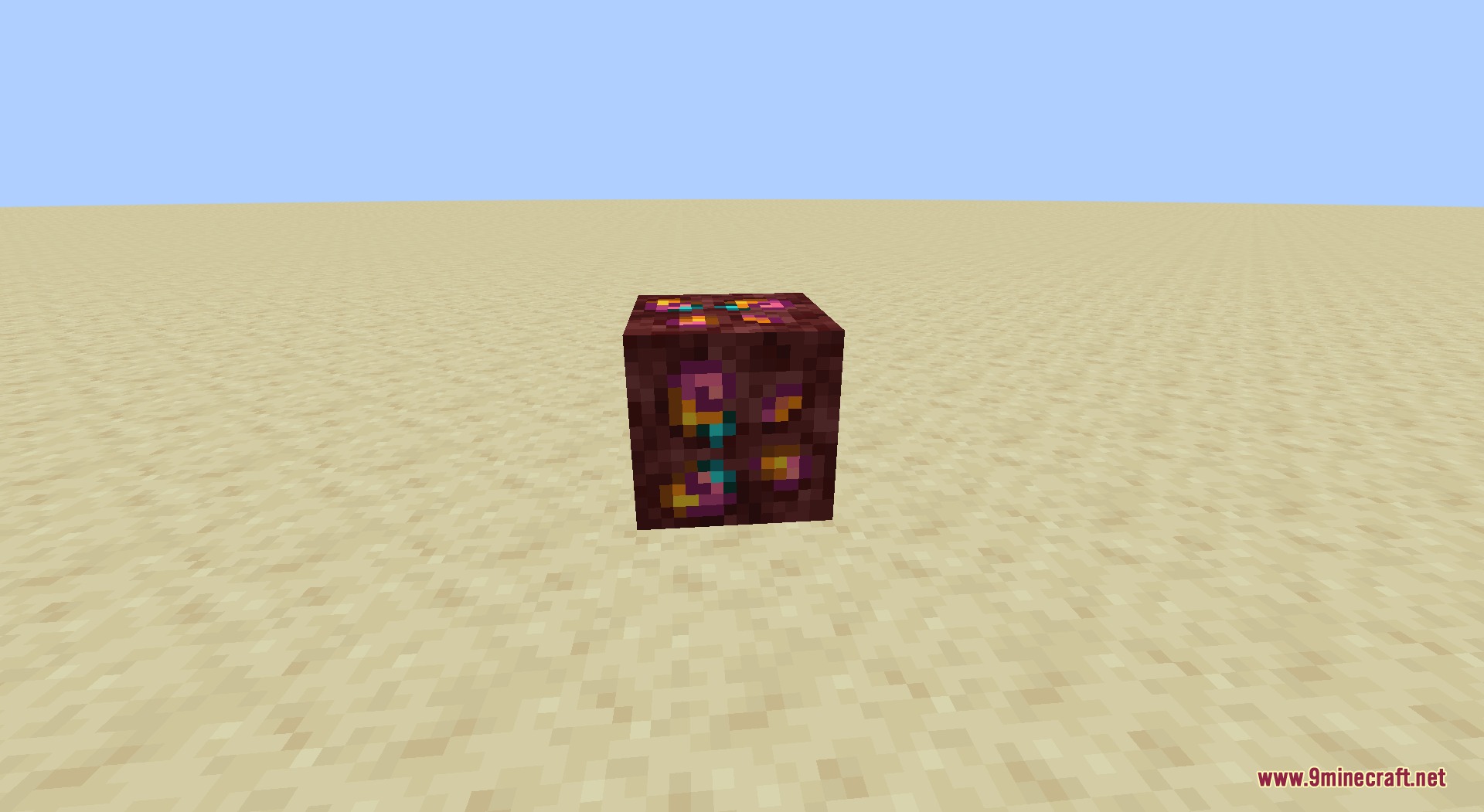 Ore Genesis Mod Screenshot 2 A netherrack block with colorful ore specks placed on a flat sandy ground