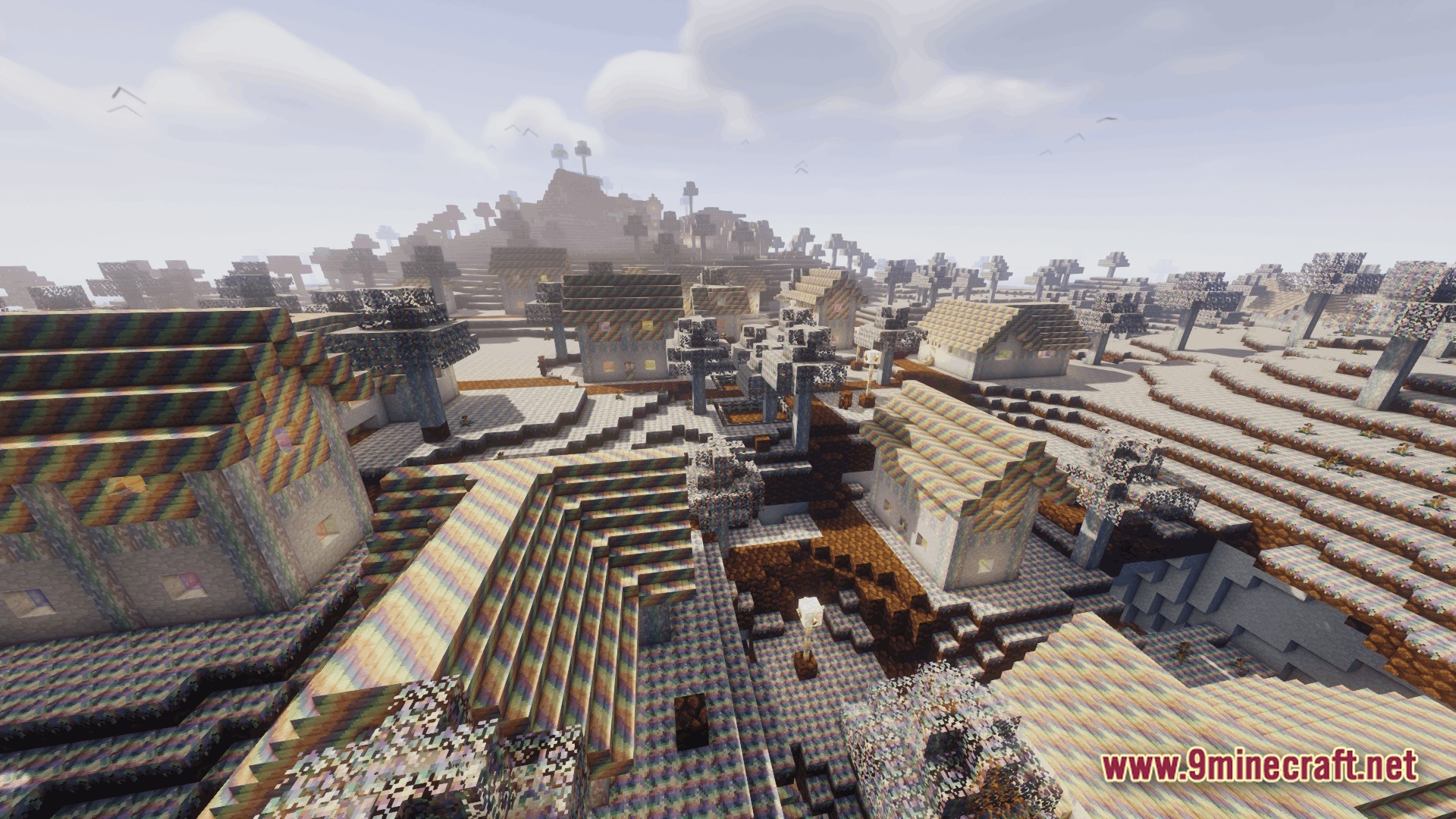 Ore Spawn Adventuree Modpack Screenshot 8 A village with rainbow-textured houses and trees situated in a hilly, multi-colored landscape