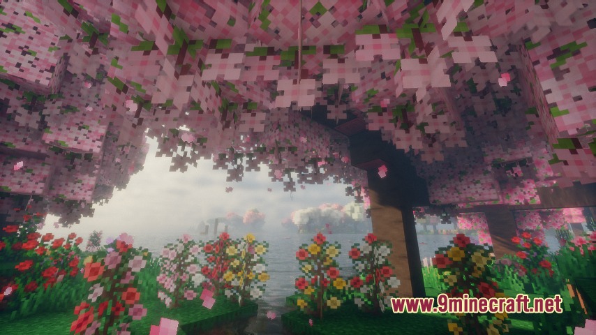 Pink blossom trees and colorful flowers overlook a peaceful lake in the forest