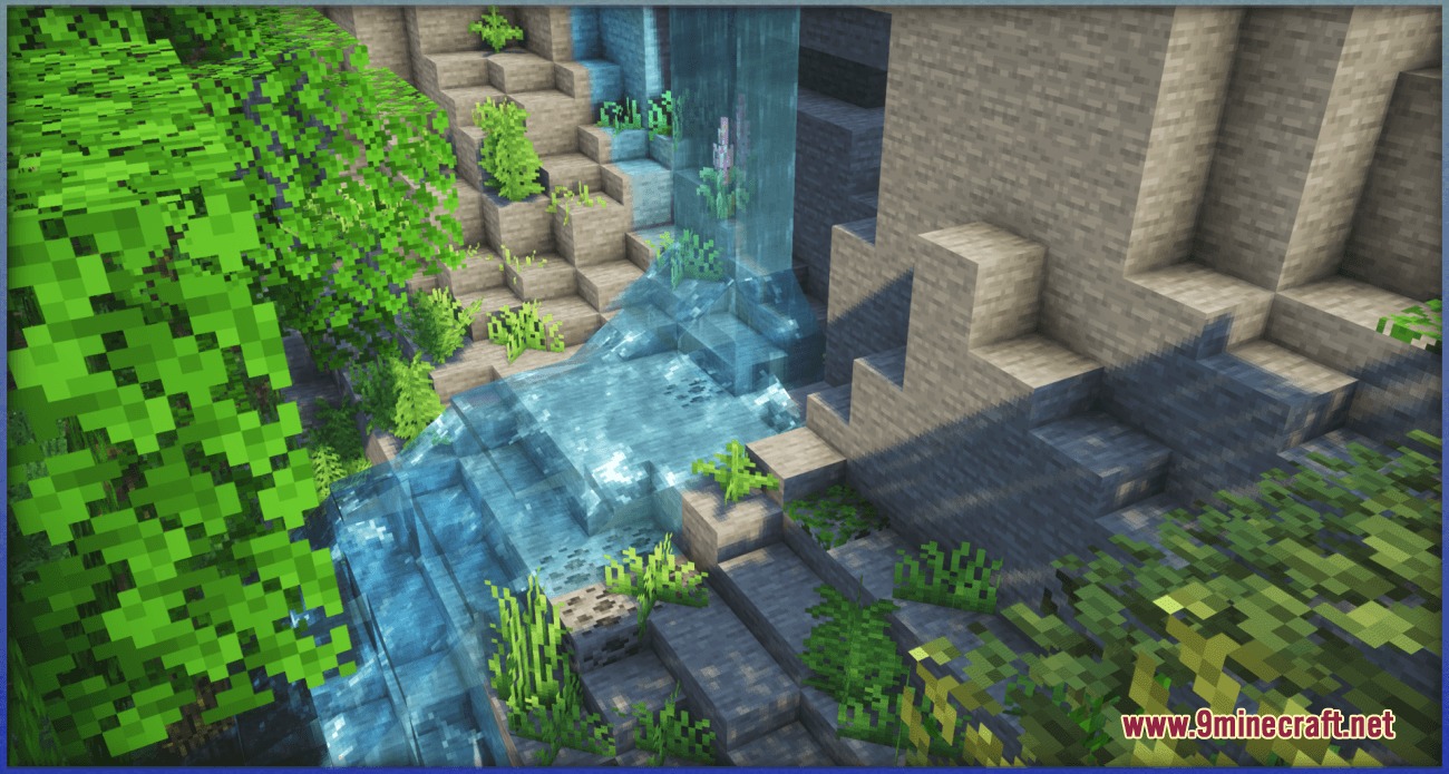 A waterfall flowing over stone blocks with small plants growing on the rocks