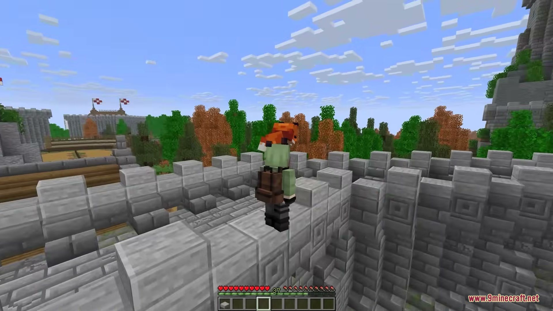 Player Charge Jump Mod Screenshot 4 Player character overlooking a forest with orange and green trees from a wall