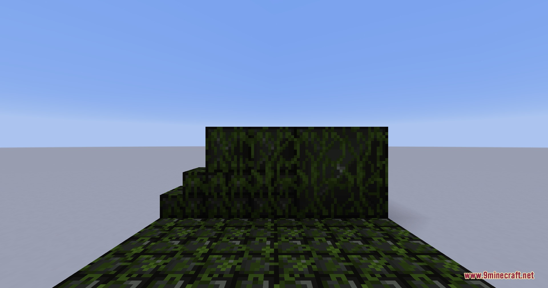 Overgrown mossy variants of the blackplate blocks displayed in a flat world