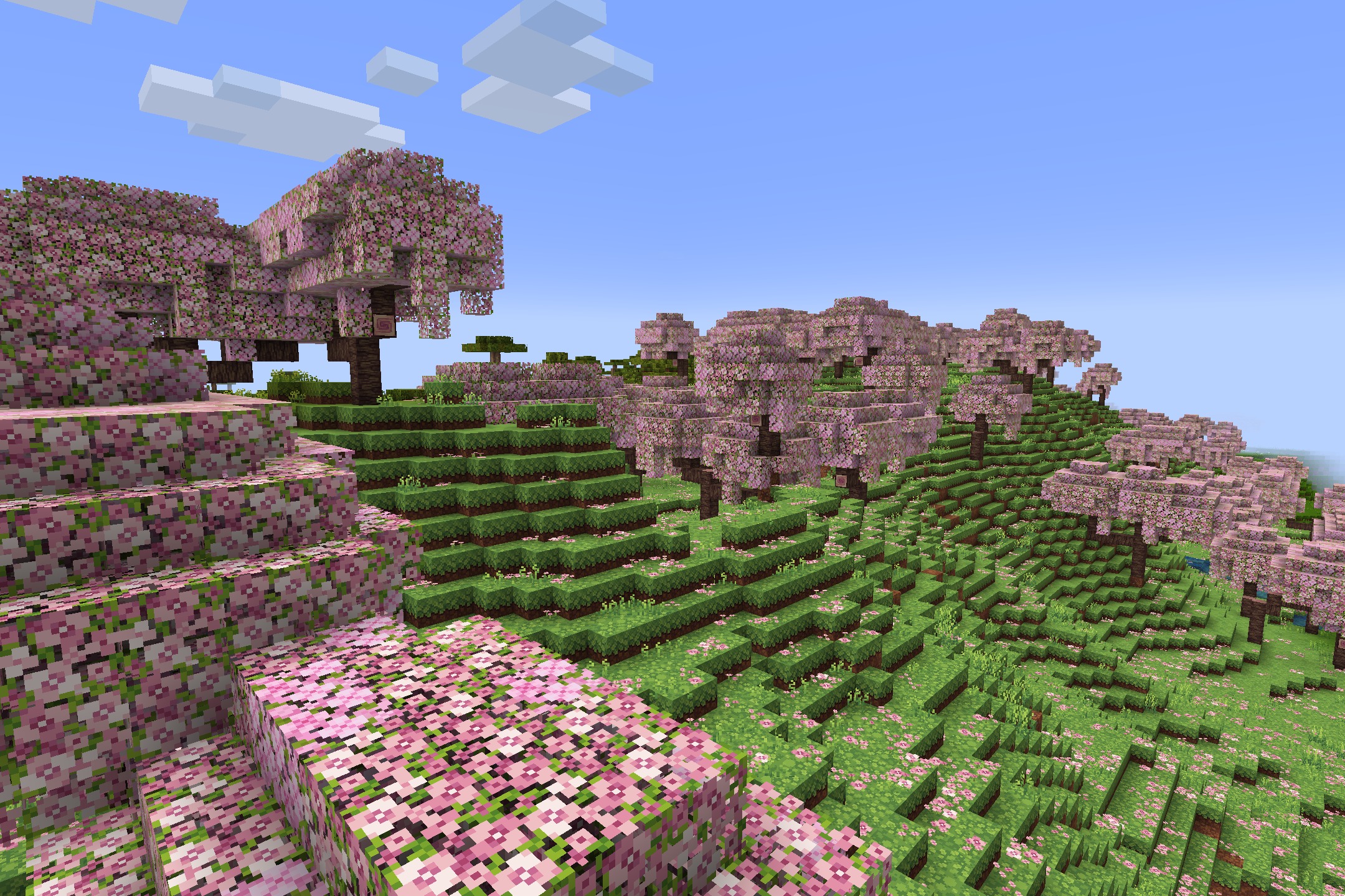 Quadral Pack Resource Pack Screenshot 1 Vibrant pink cherry blossom trees covering a lush green hillside in Minecraft