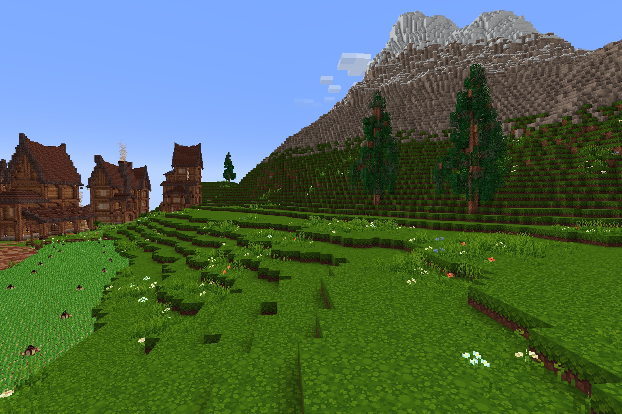 Quadral Pack Resource Pack Screenshot 4 Lush green hills and tall mountains next to large wooden houses in Minecraft